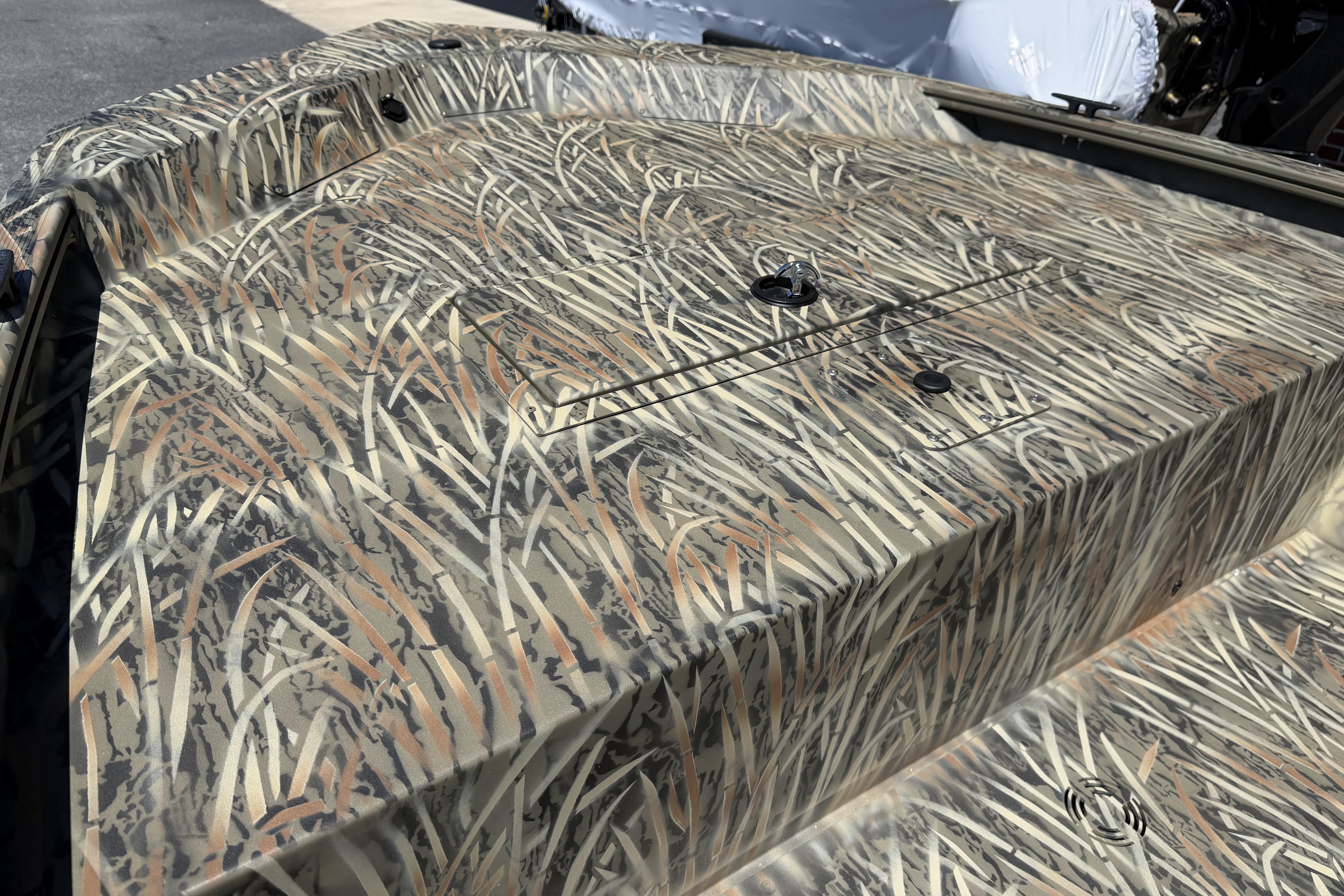 Camouflage-patterned deck of 2026 Tracker Grizzly 1648 SC boat in outdoor setting.