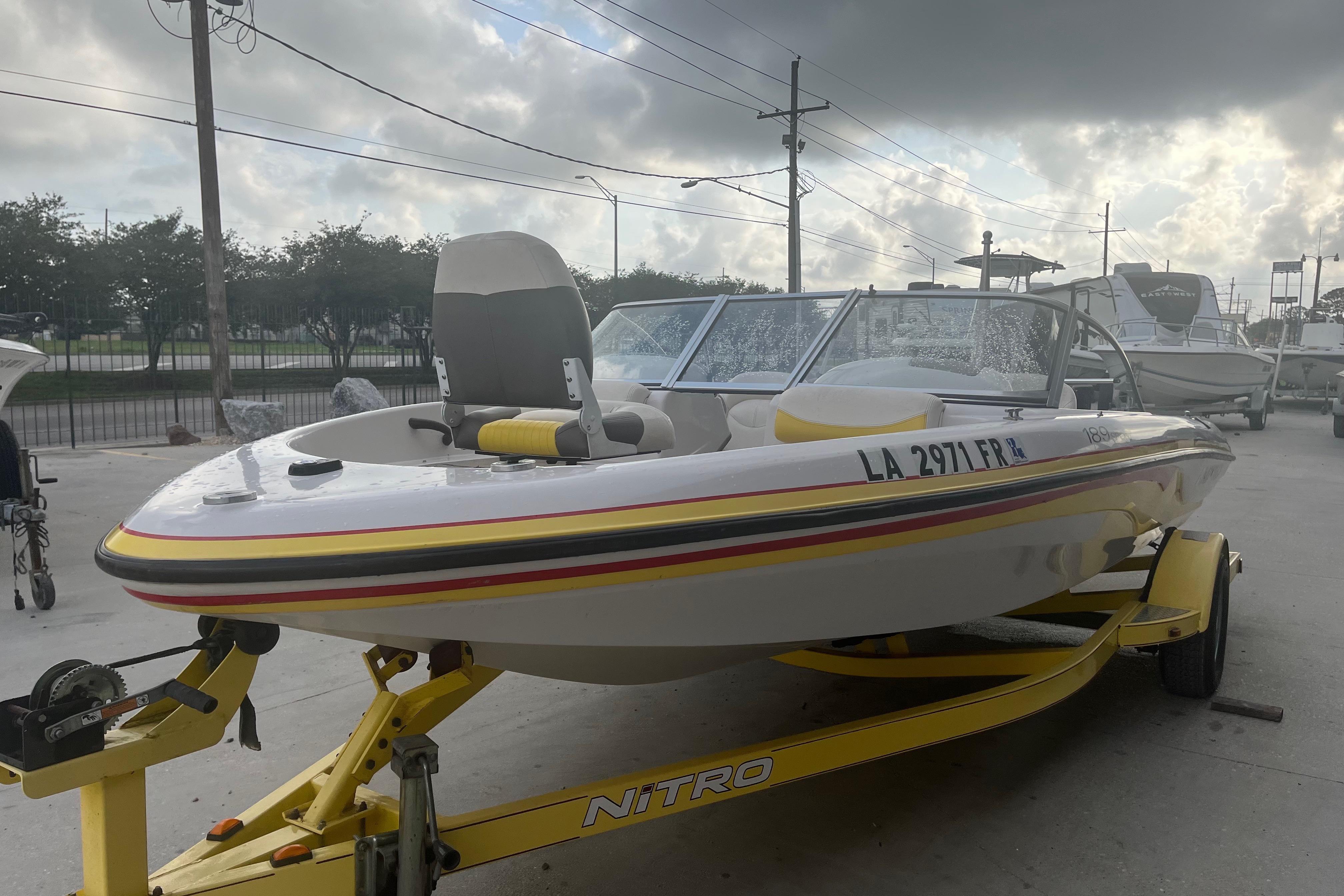 2006 Nitro 189 Sport boat on trailer, parked outdoors under cloudy sky.
