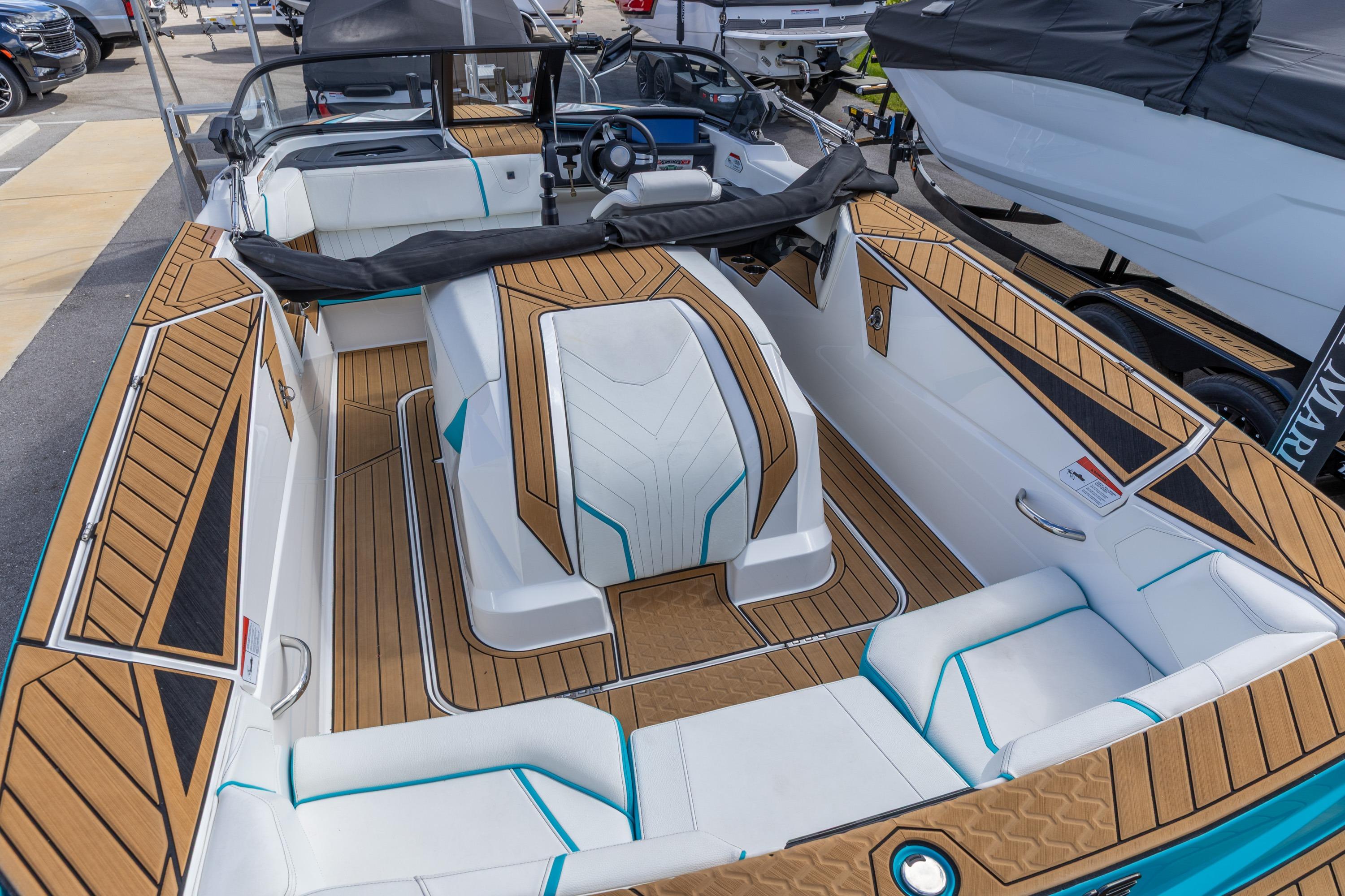 2023 Nautique Ski Nautique boat interior with teak flooring and white seating.