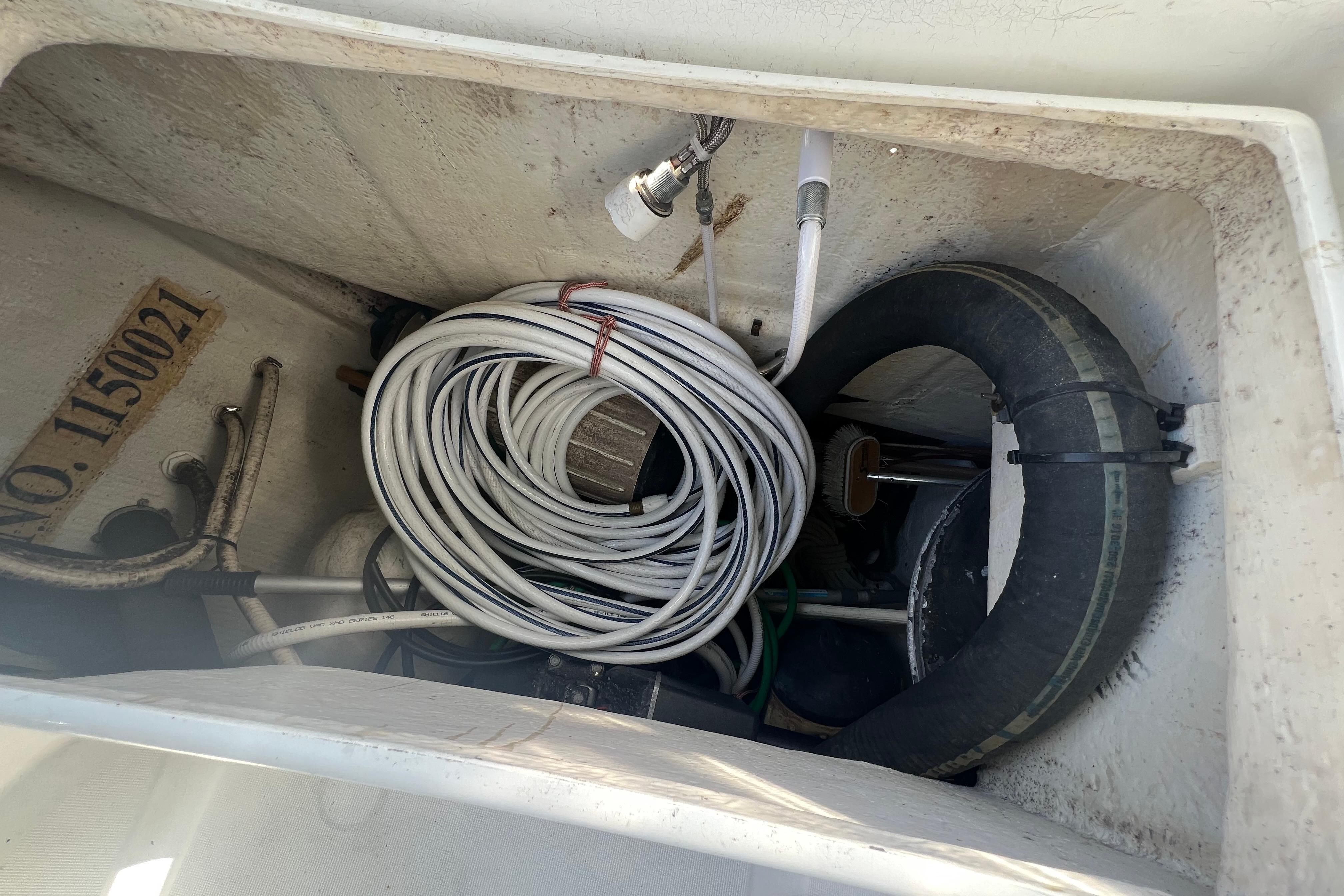 Storage compartment of a 2001 Beneteau Oceanis 473 sailboat with coiled cables and equipment.