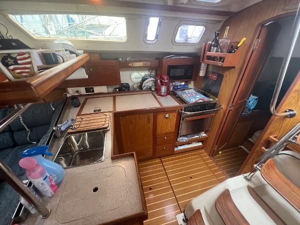 Interior view of a 2000 Hunter 410 with a kitchen and wood paneling.