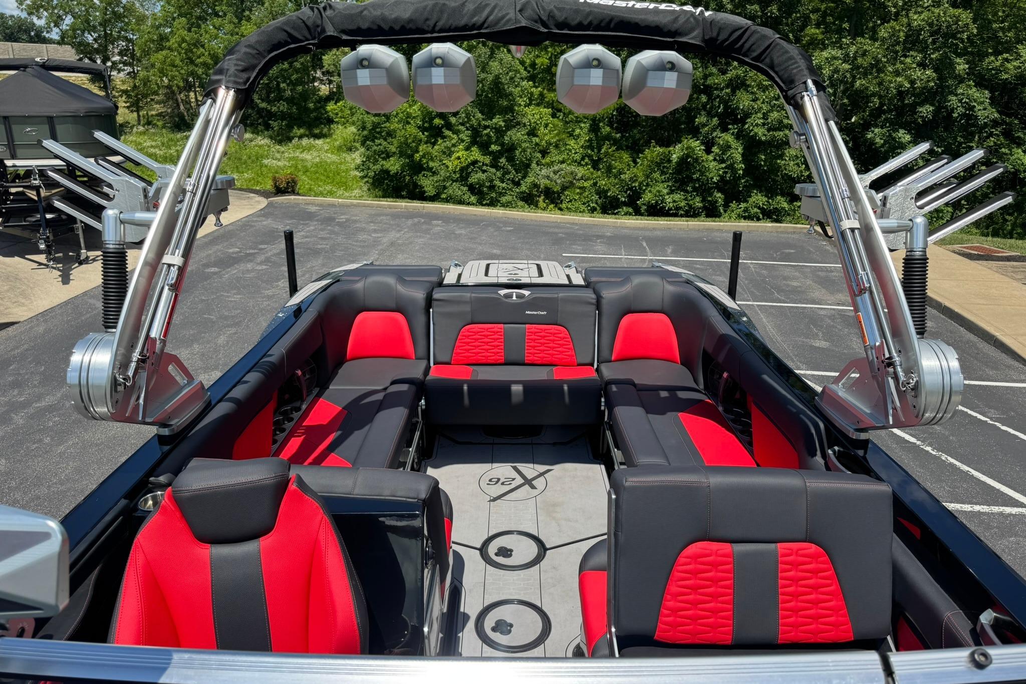 2021 MasterCraft X26 boat interior with red and black seating, parked outdoors.