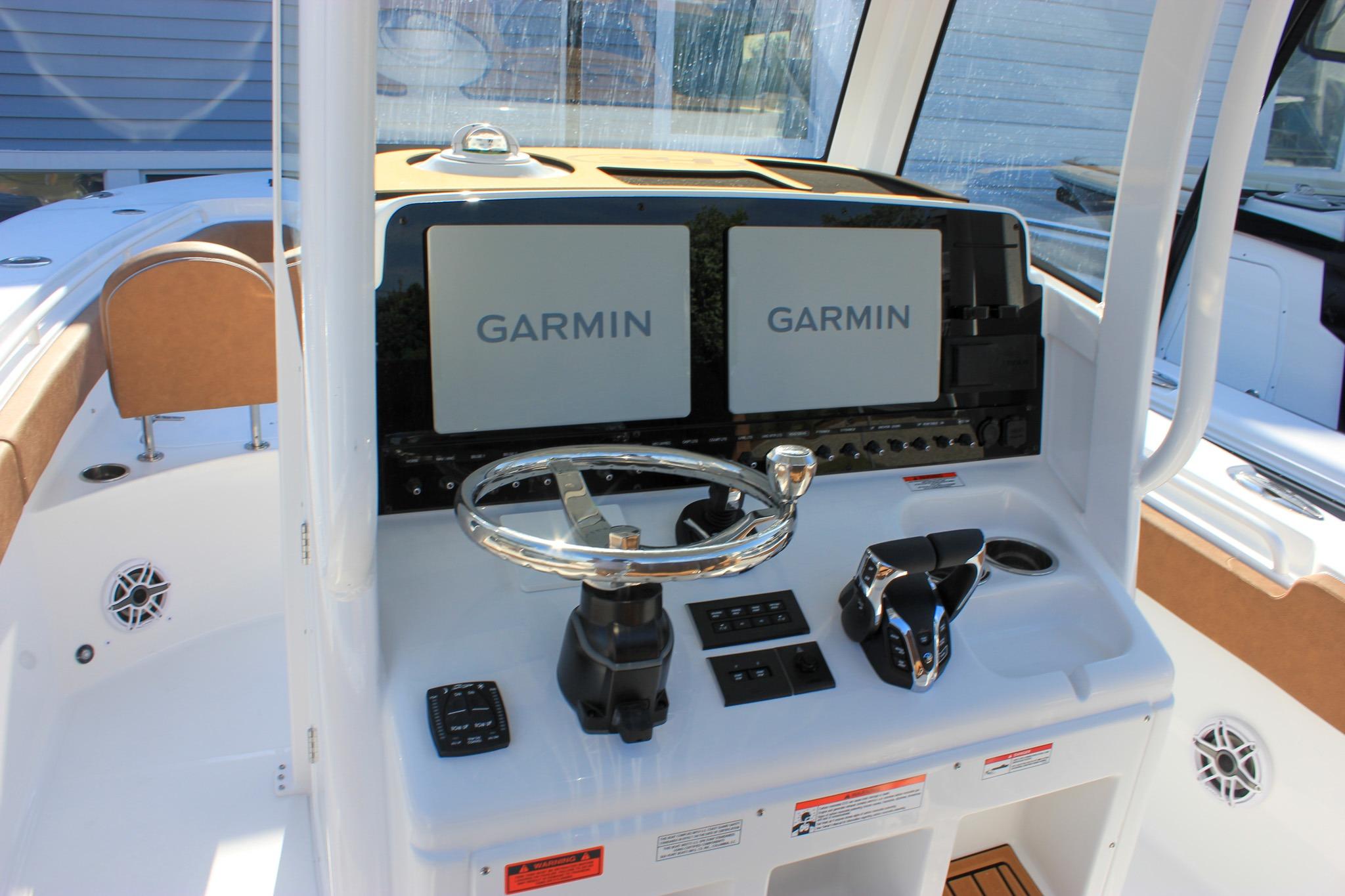 2027 Sea Hunt Ultra 275 SE boat dashboard with Garmin navigation displays and steering wheel.