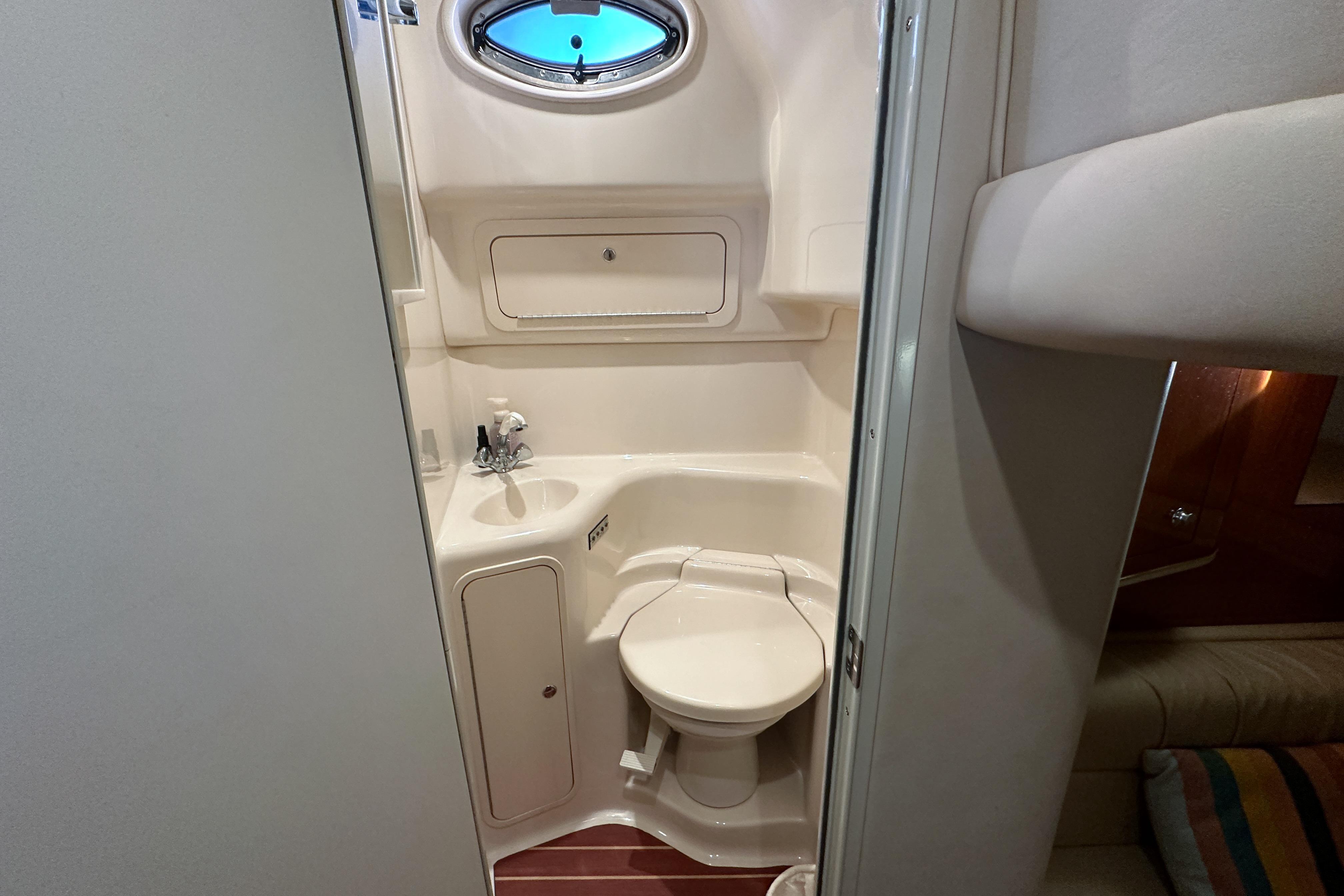 Compact bathroom in 2001 Sea Ray 410 Sundancer yacht, featuring toilet and sink.