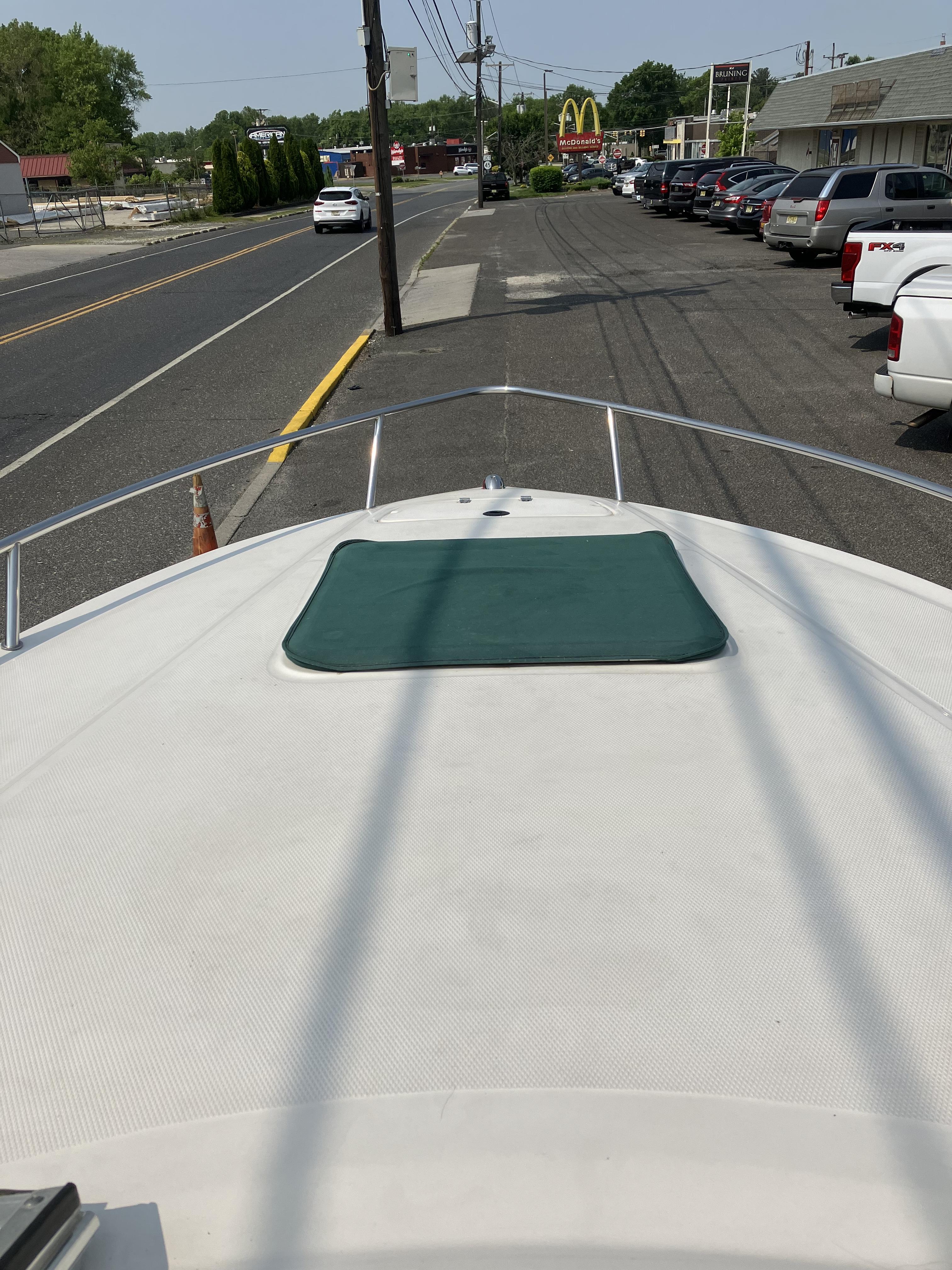 The image shows the bow deck of a 2001 Chaparral 235 SSi boat parked on a street.