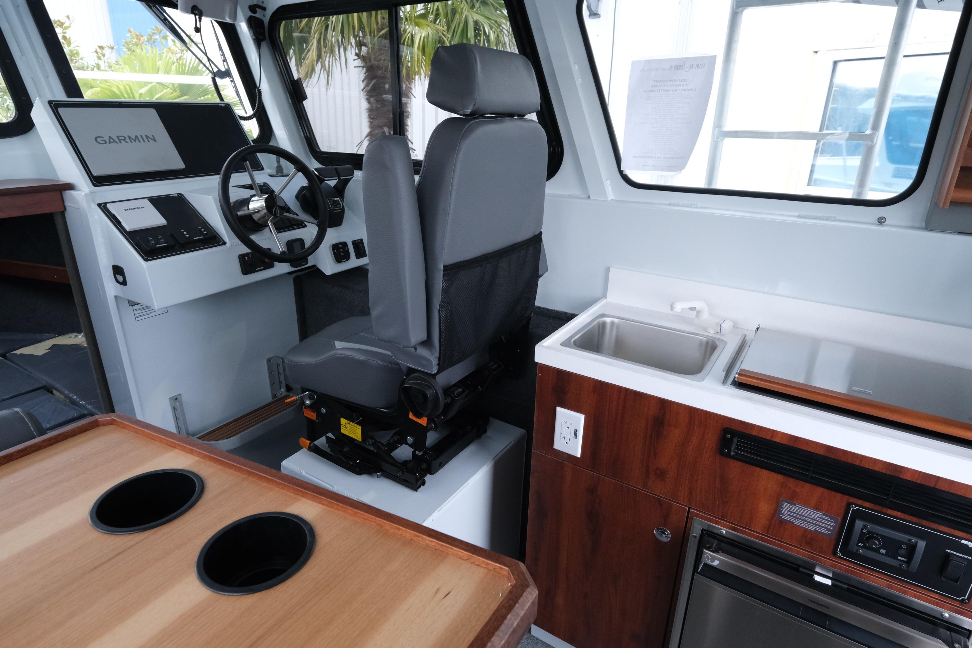 Interior of 2026 Hewescraft 270 Pacific Explorer with helm, sink, and seating.