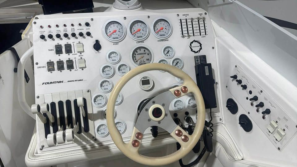 Dashboard of a 1996 Fountain 42Ft boat with steering wheel and gauges.