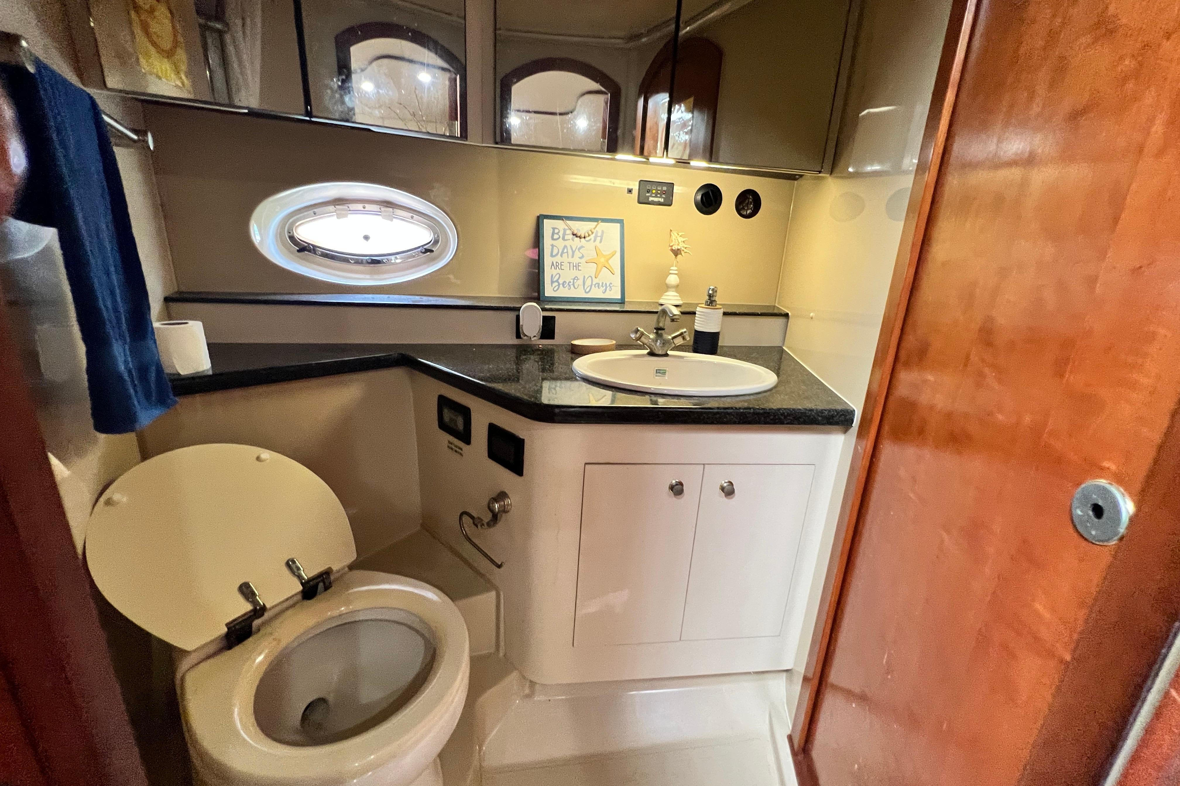 Luxurious bathroom in 2005 Cruisers Yachts 440 Express with modern fixtures and porthole window.