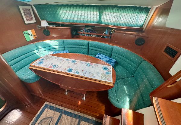 Cozy interior of 1996 Beneteau Oceanis 40 CC with green seating and wooden accents.