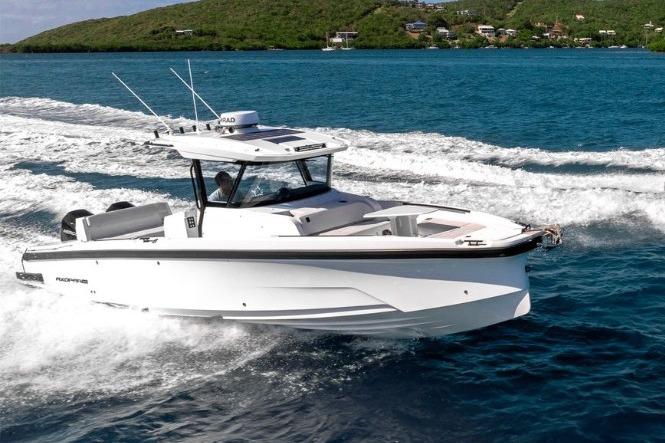 2025 Axopar 29 CCX cruising on blue ocean near lush green island.