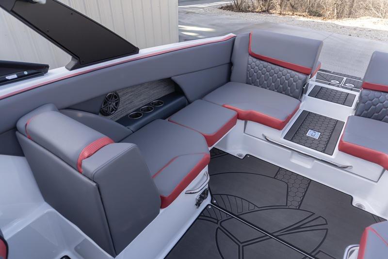 2026 Scarab 255 LX Wake boat interior with gray and red seating, cup holders, and stylish flooring.