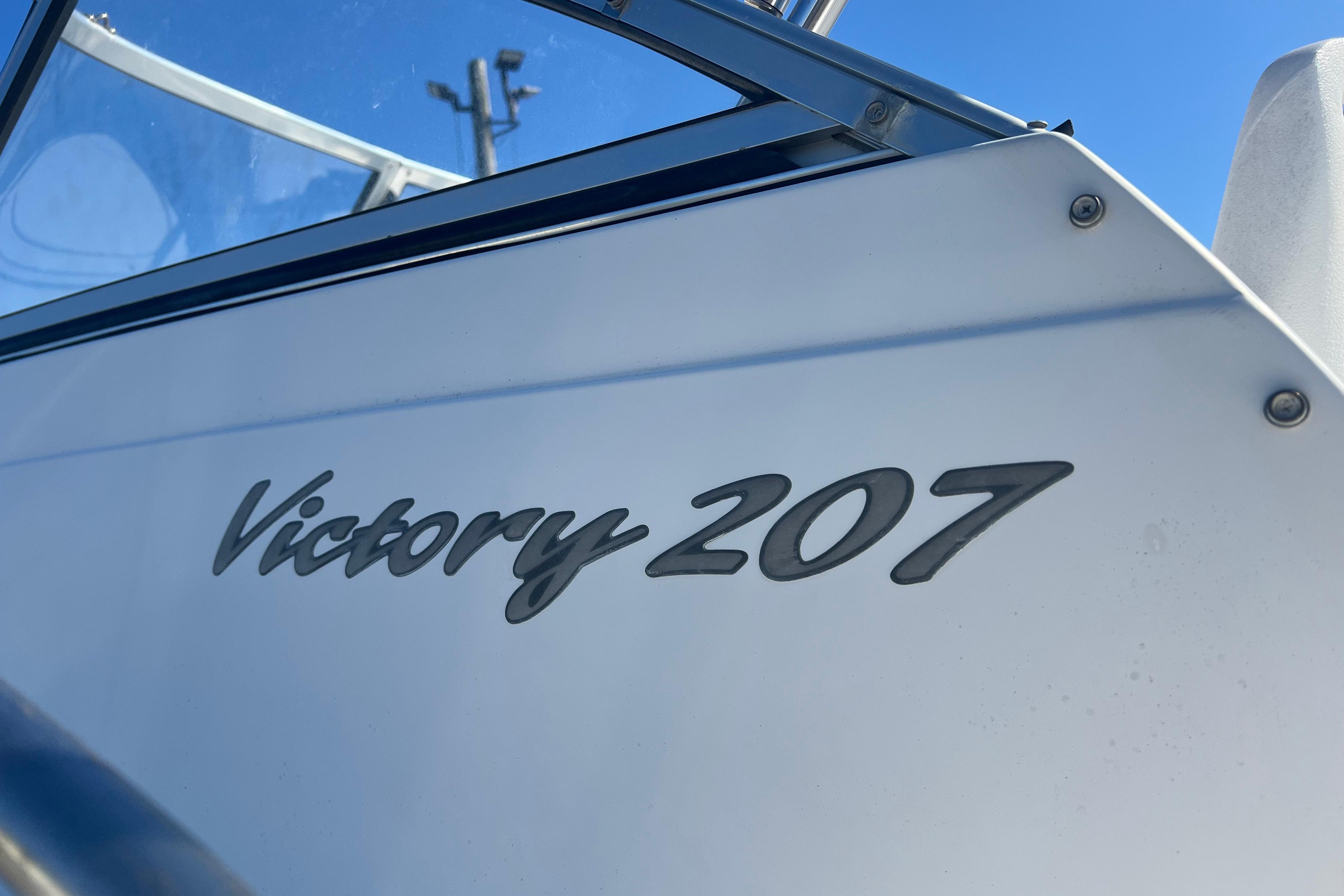 2008 Sea Hunt Victory 207 boat nameplate against clear blue sky.