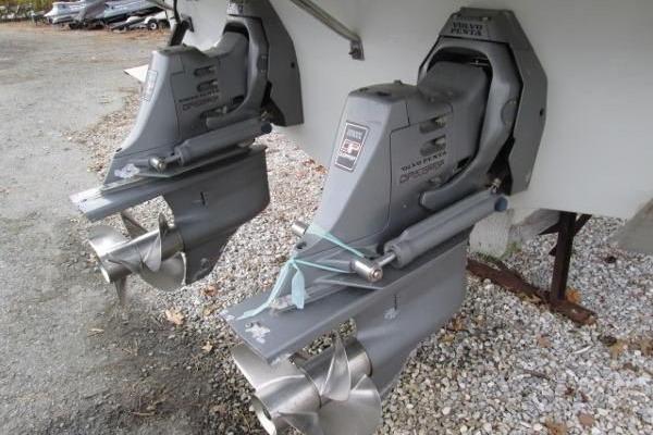 2004 Crownline 288 BR boat propellers and outdrives on gravel surface.