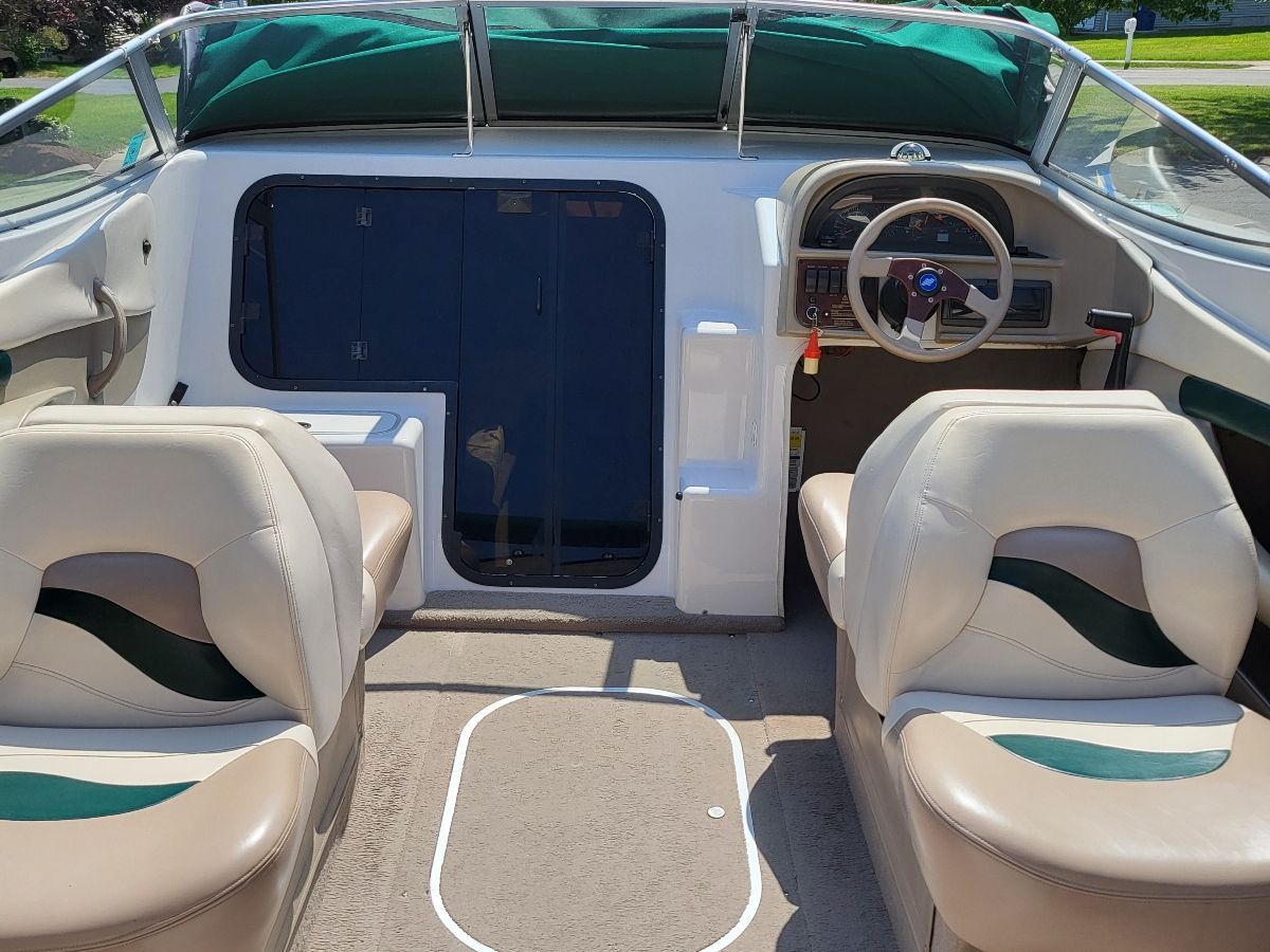 The image shows the cockpit of a 1996 Four Winns 245 Sundowner with two seats and a helm.