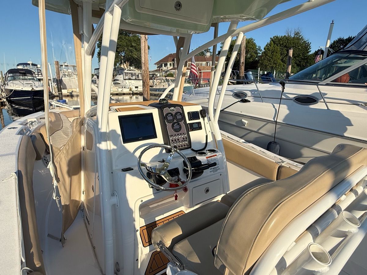 The image shows the cockpit of a 2017 Sea Fox Commander 266 boat at a marina.