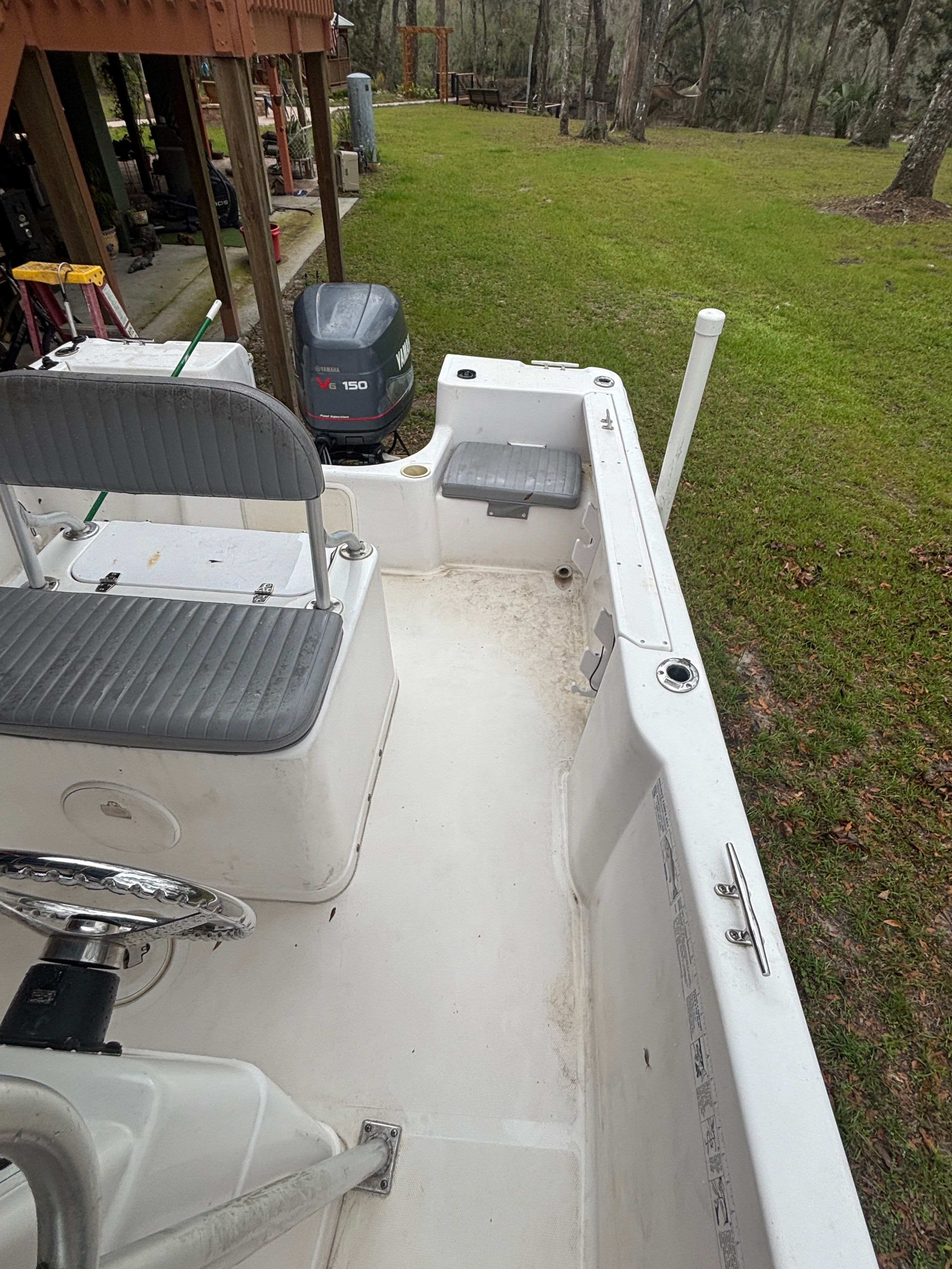 2003 Pro-Line Sport 20 boat with outboard motor in yard.