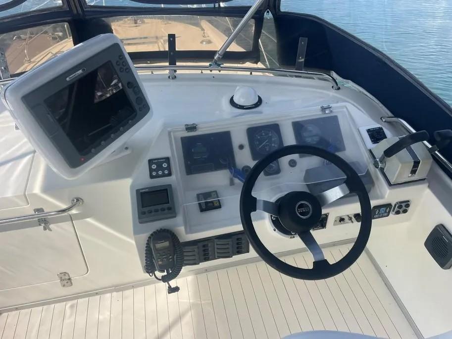 1985 Princess Sedan Flybridge helm with steering wheel, navigation controls, and display screen.