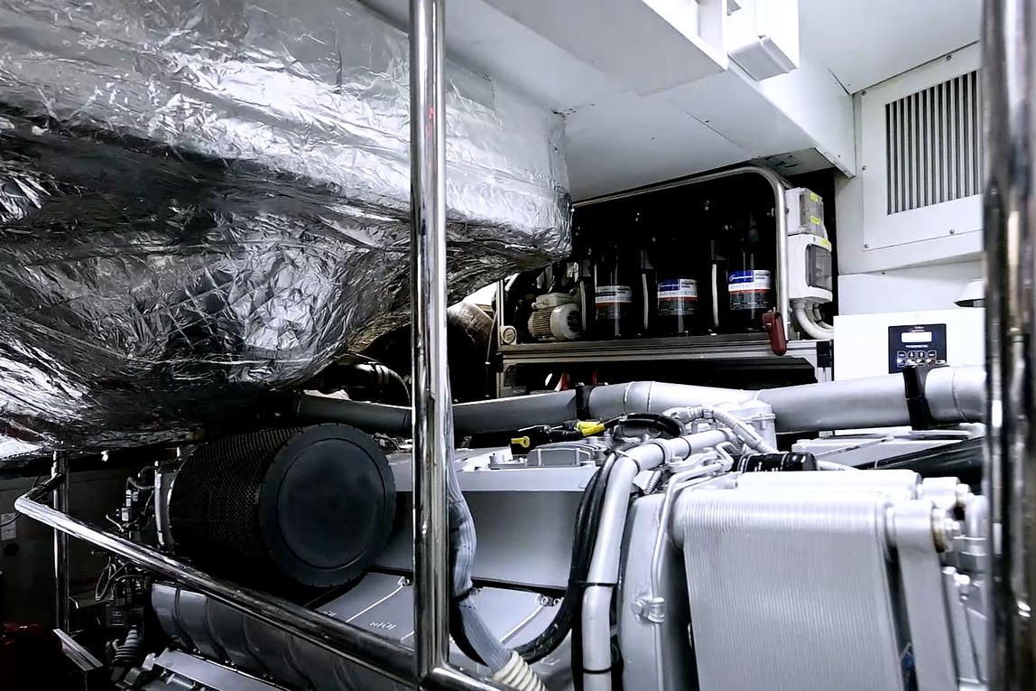 Engine room of a 2015 Pershing 92 yacht, showcasing complex machinery and components.