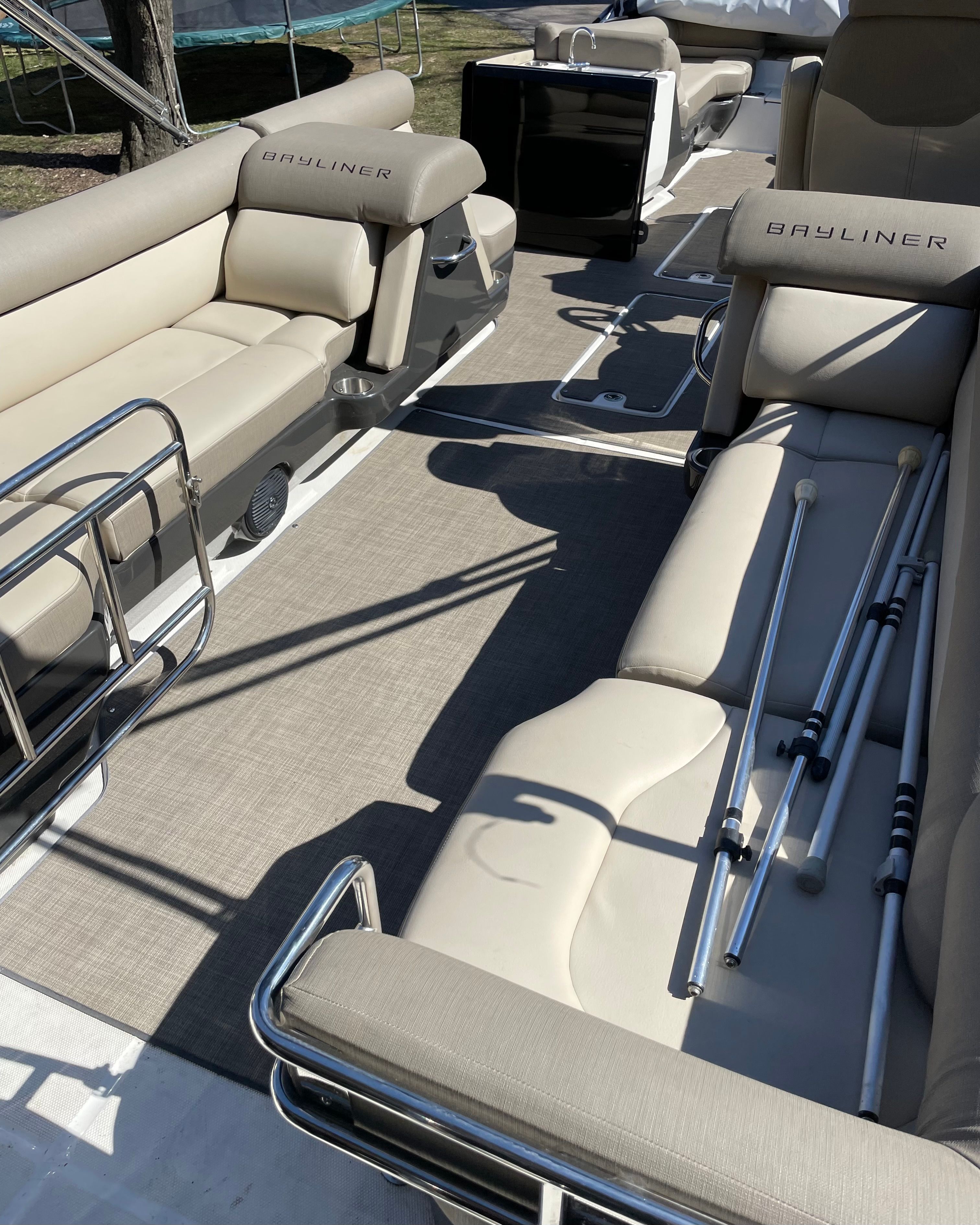 The image shows the interior of a 2016 Bayliner Element XR7 with beige seating and metal railings.