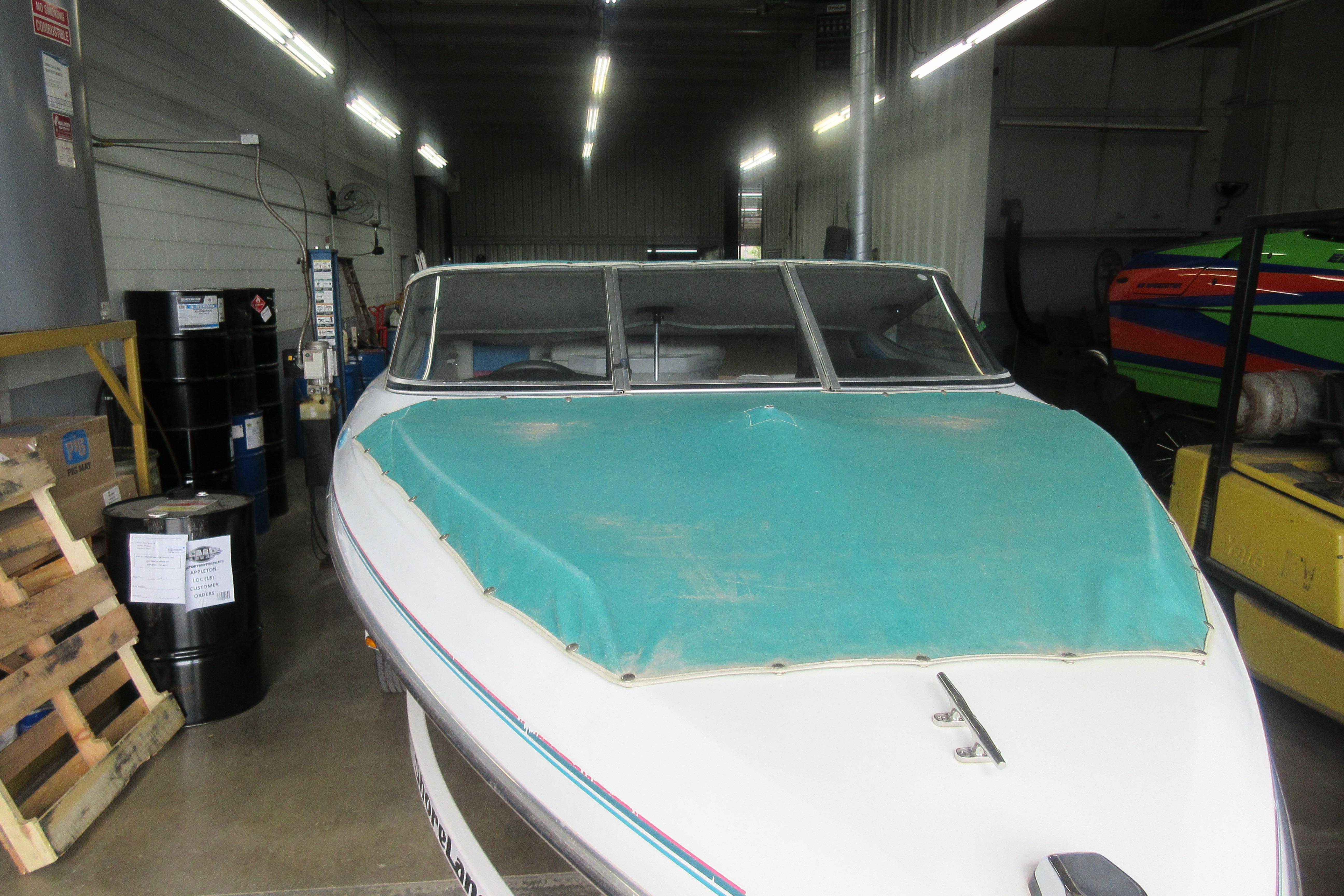 1993 Rinker 186 Captiva Bowrider with teal cover in a storage facility.