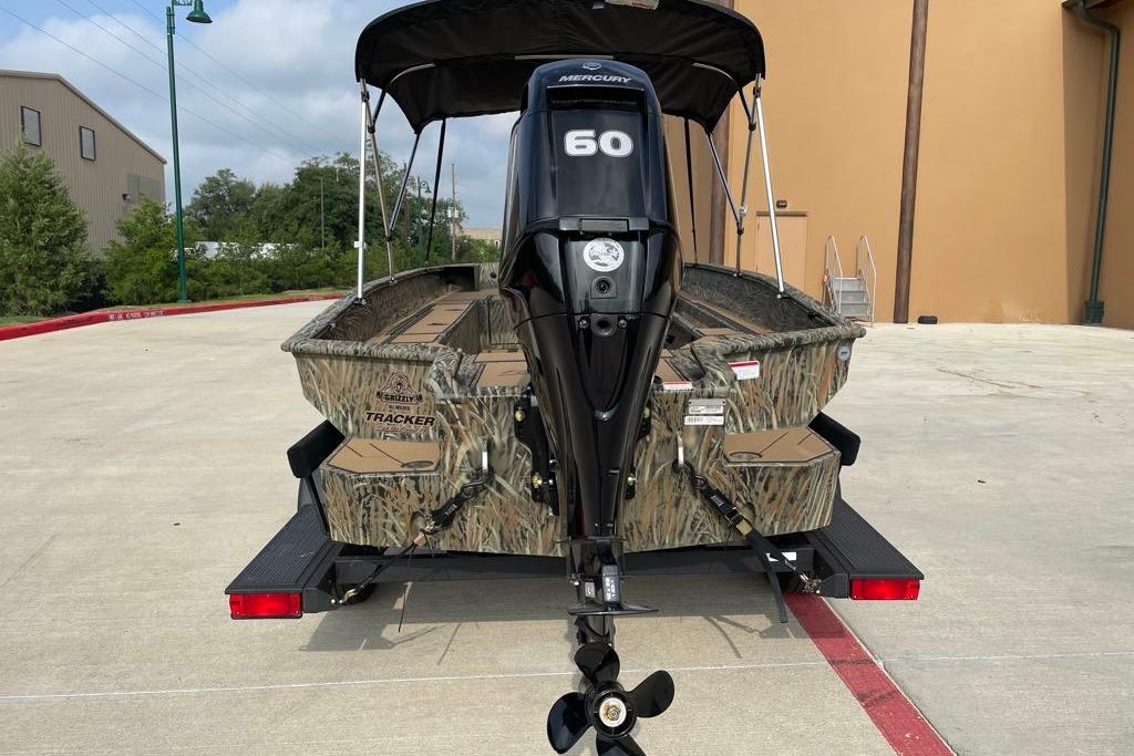 2026 Tracker Grizzly 1756 T Marsh boat with Mercury 60 engine, parked outdoors.
