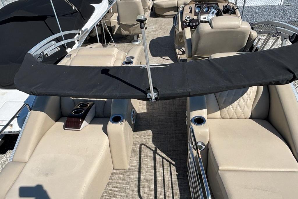 2014 Bennington 2575 RCW pontoon boat interior with beige seating and black canopy.