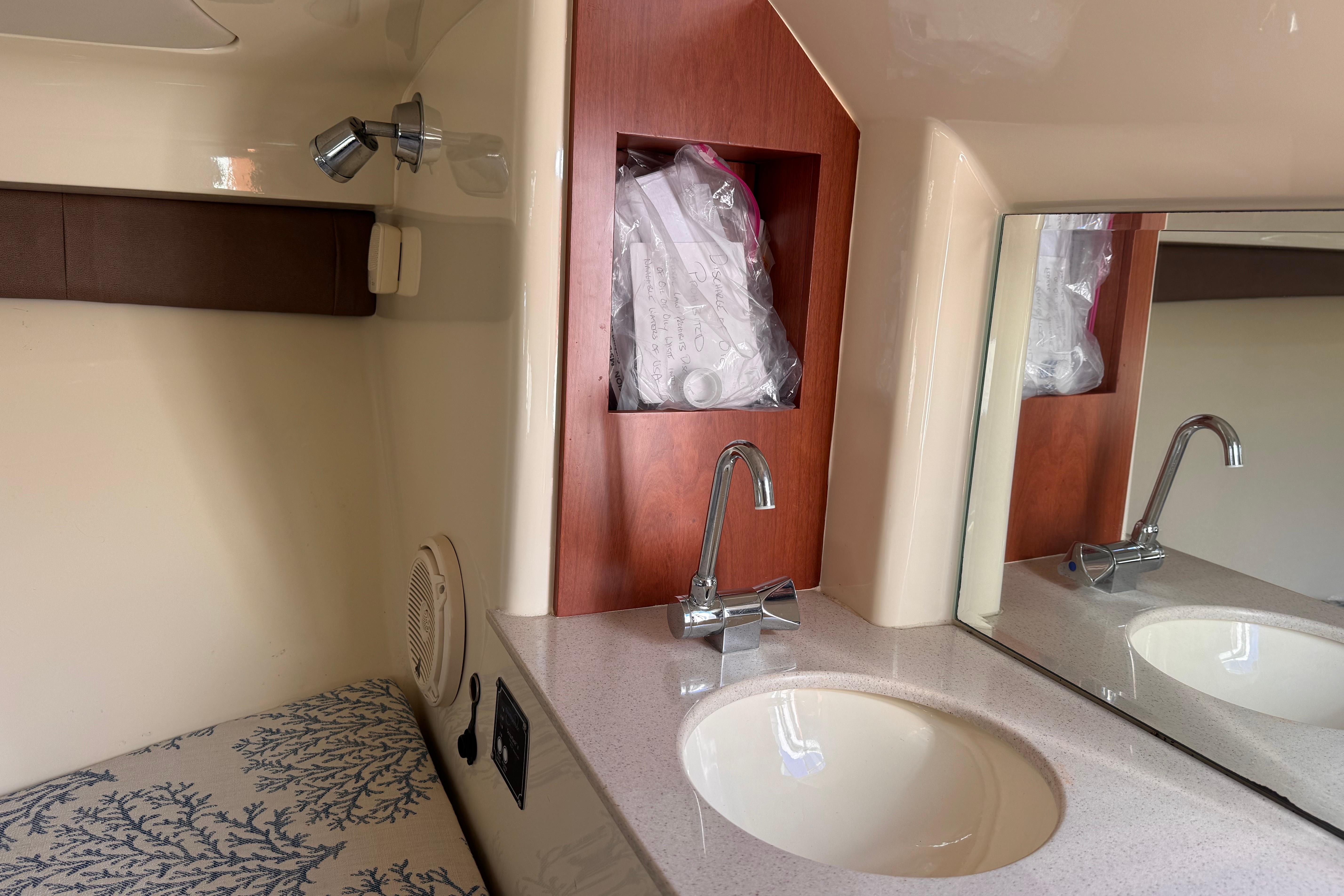 2019 Chris-Craft Corsair 30 interior with sink, mirror, and storage compartment.