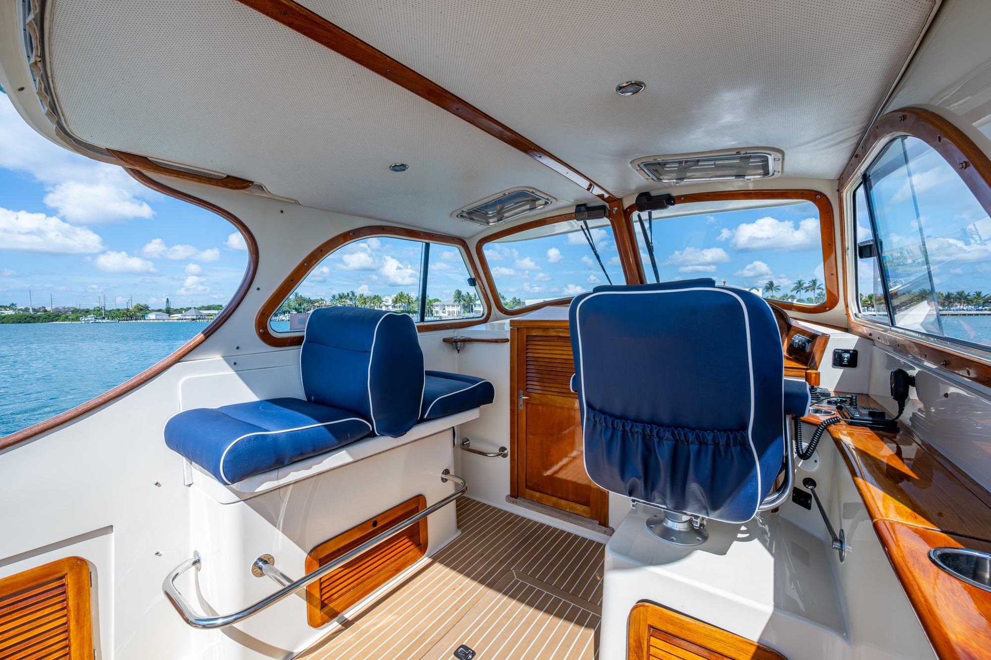 Interior of 2001 Hinckley Picnic Boat Classic with blue seating and wooden accents.