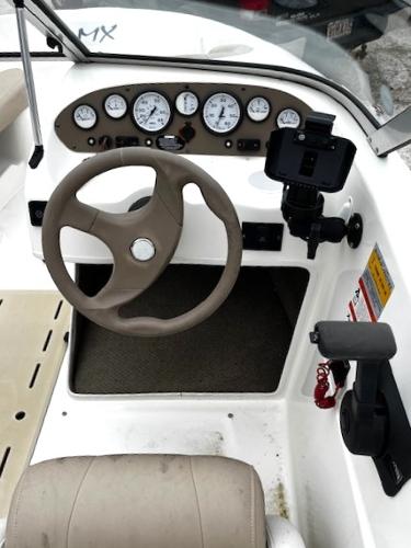 2005 Glastron MX boat dashboard with steering wheel and instrument panel.