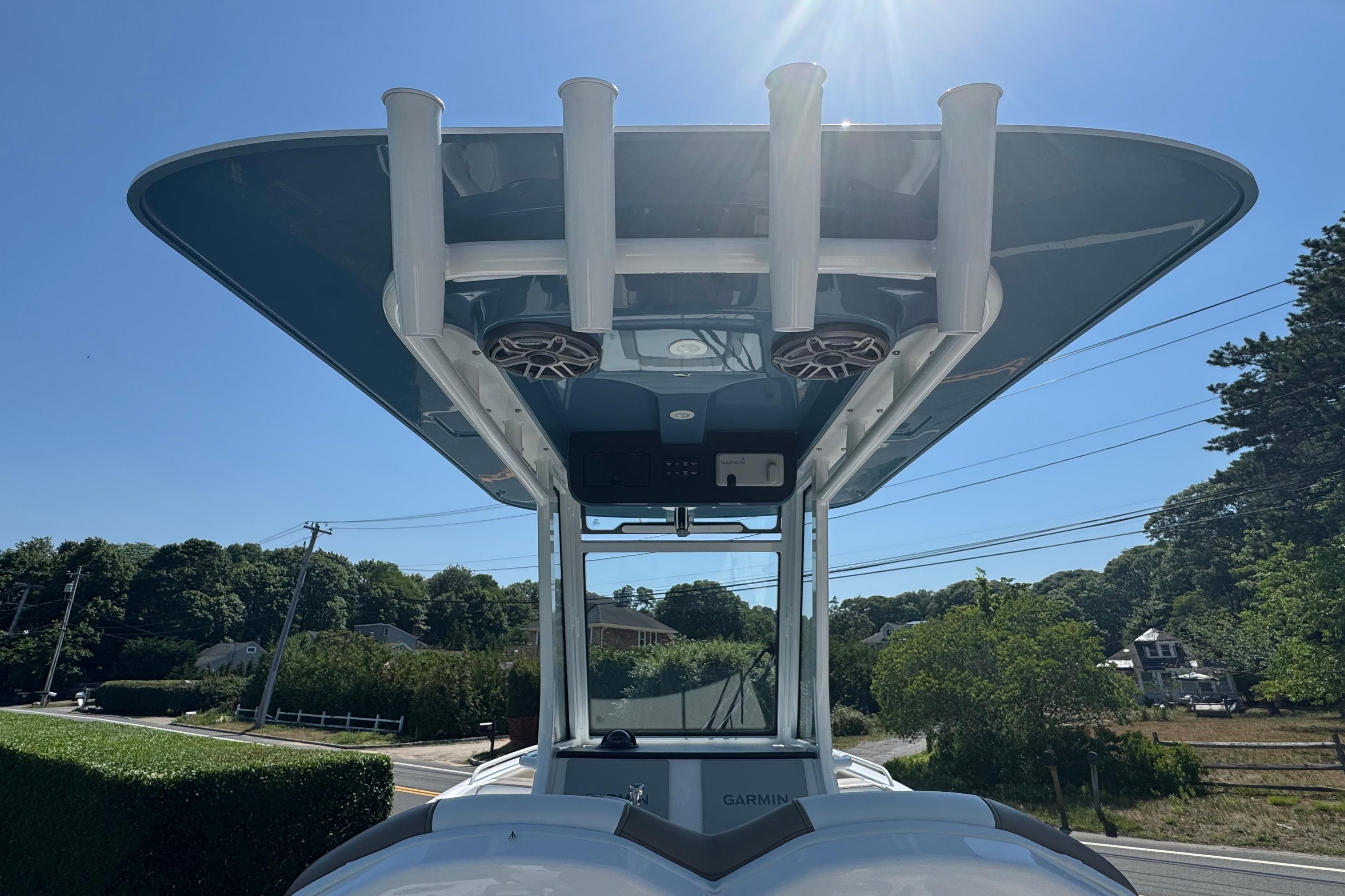 2026 Edgewater 250CC boat with T-top and rod holders under clear blue sky.
