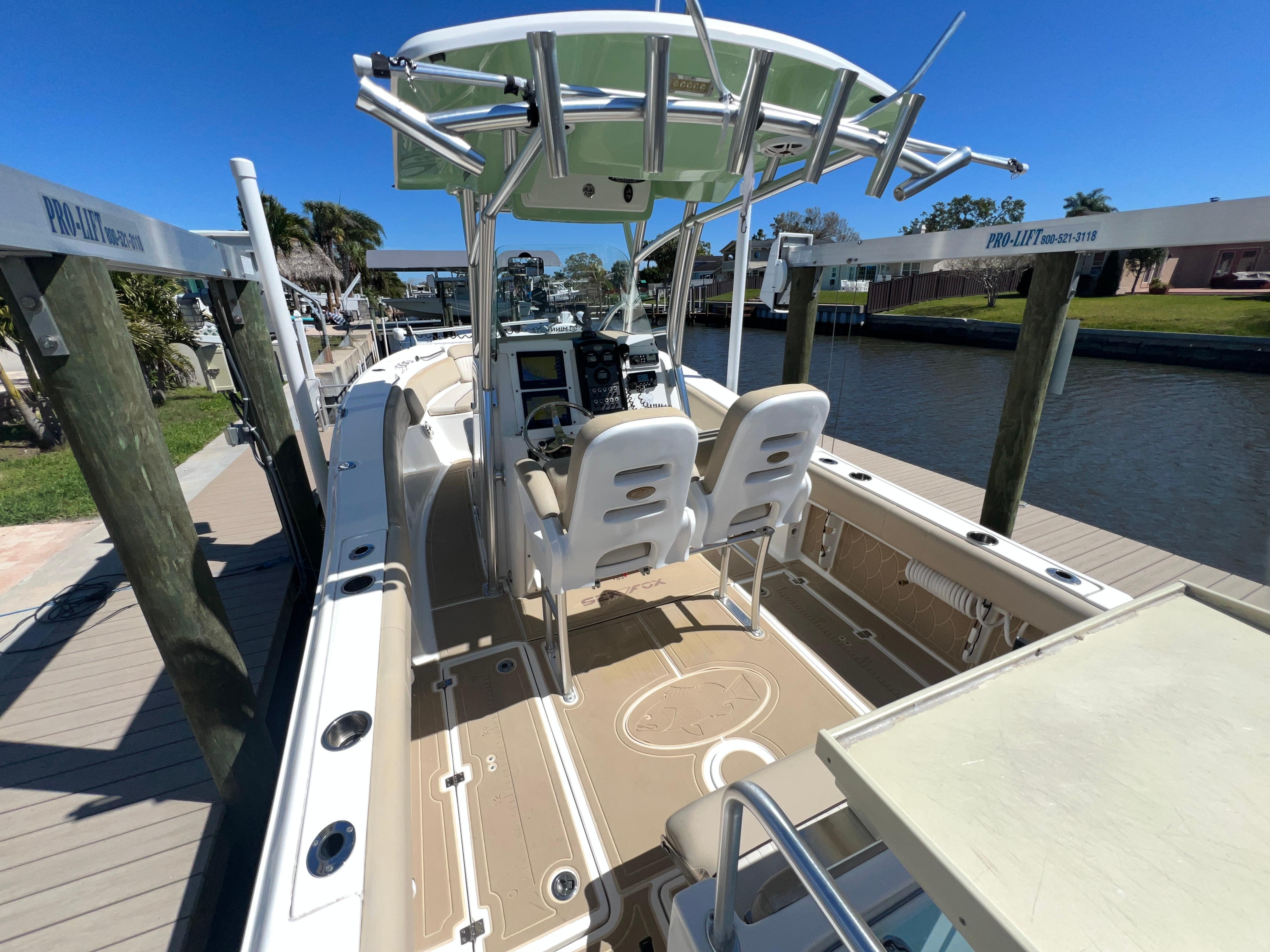 2016 Sea Fox 266 Commander boat docked, featuring dual seats and a center console.