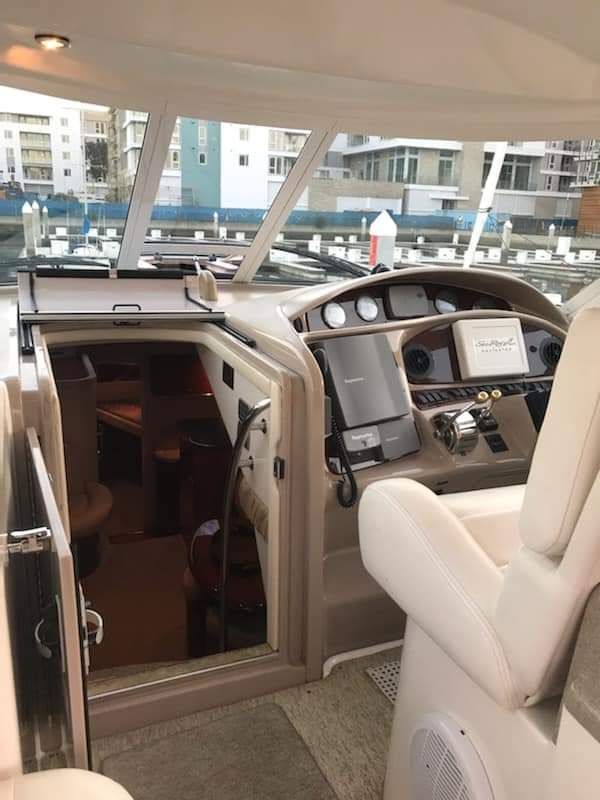 Interior view of a 2004 Sea Ray Sedan Bridge with helm and cabin entrance.