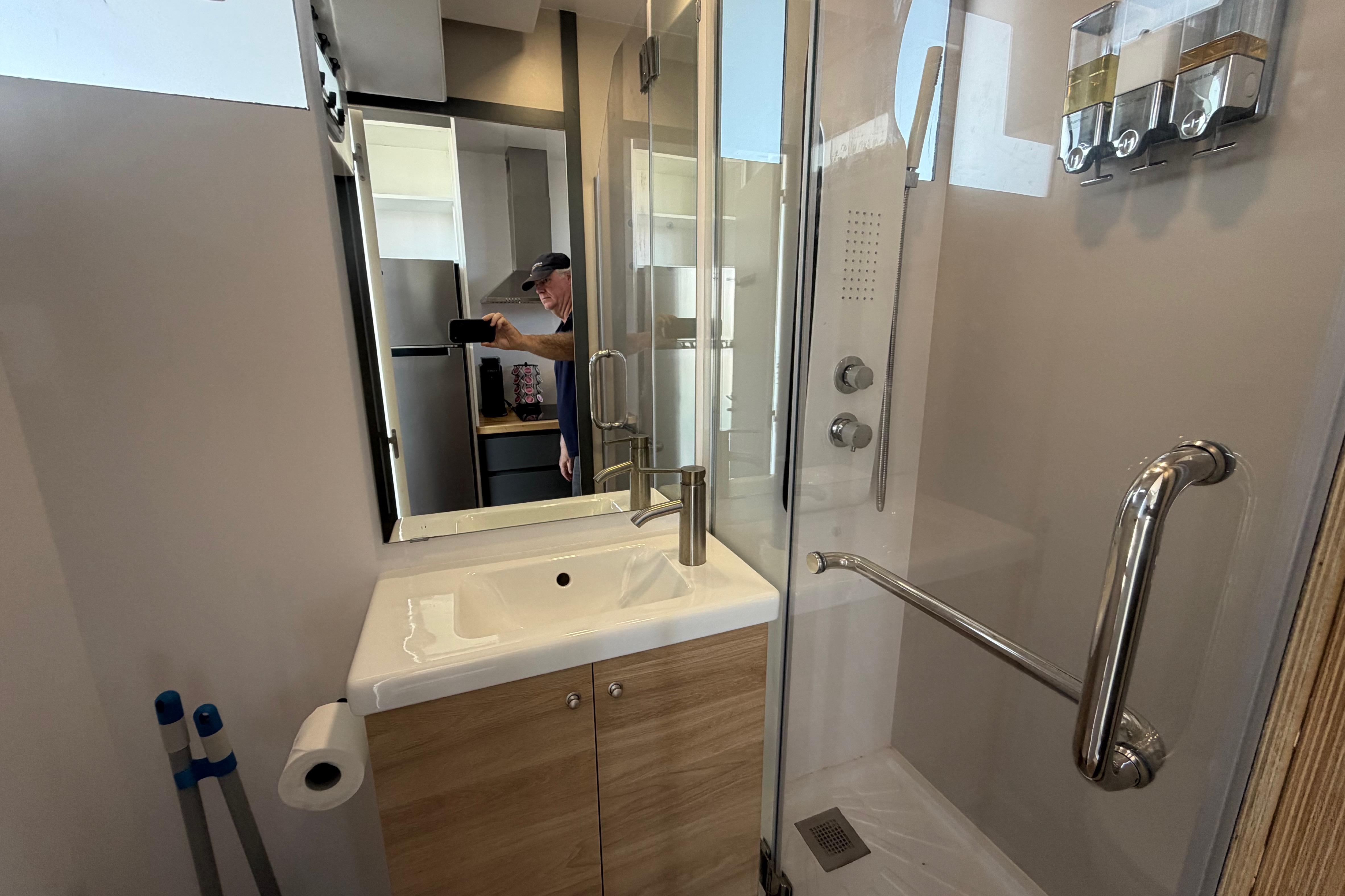 Modern bathroom in 2022 Navisyo NV.08 with shower, sink, and storage.