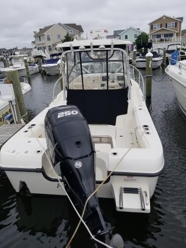 2011 Boston Whaler 235 Conquest boat docked in a marina, rear view.