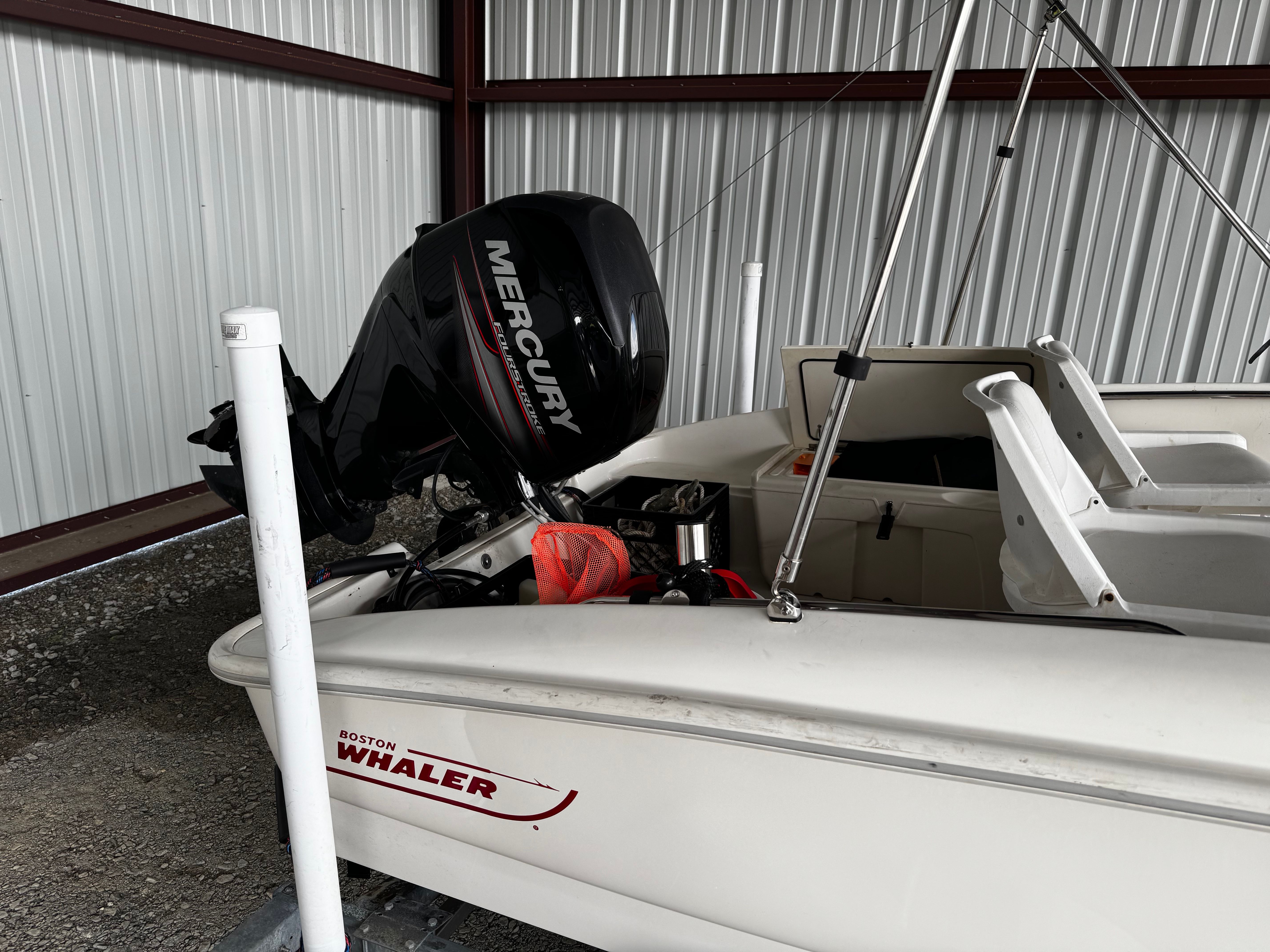 A 2015 Boston Whaler 150 Super Sport in a storage facility. The outboard motor is by Mercury.