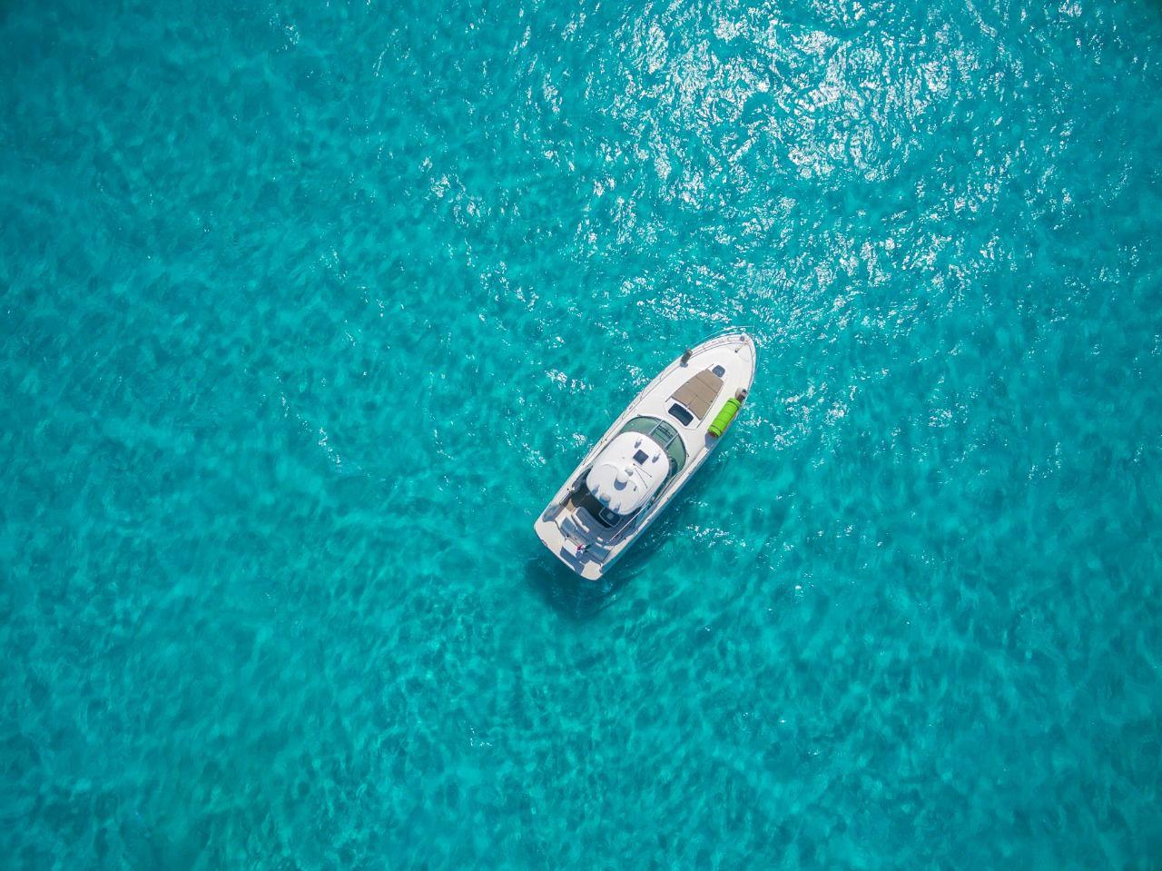 Aerial view of 2006 Sea Ray 440 Sundancer on clear turquoise water.