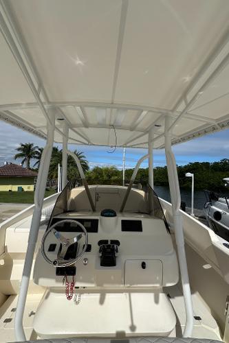 2005 Intrepid 323 boat cockpit with steering wheel and controls, under a canopy.