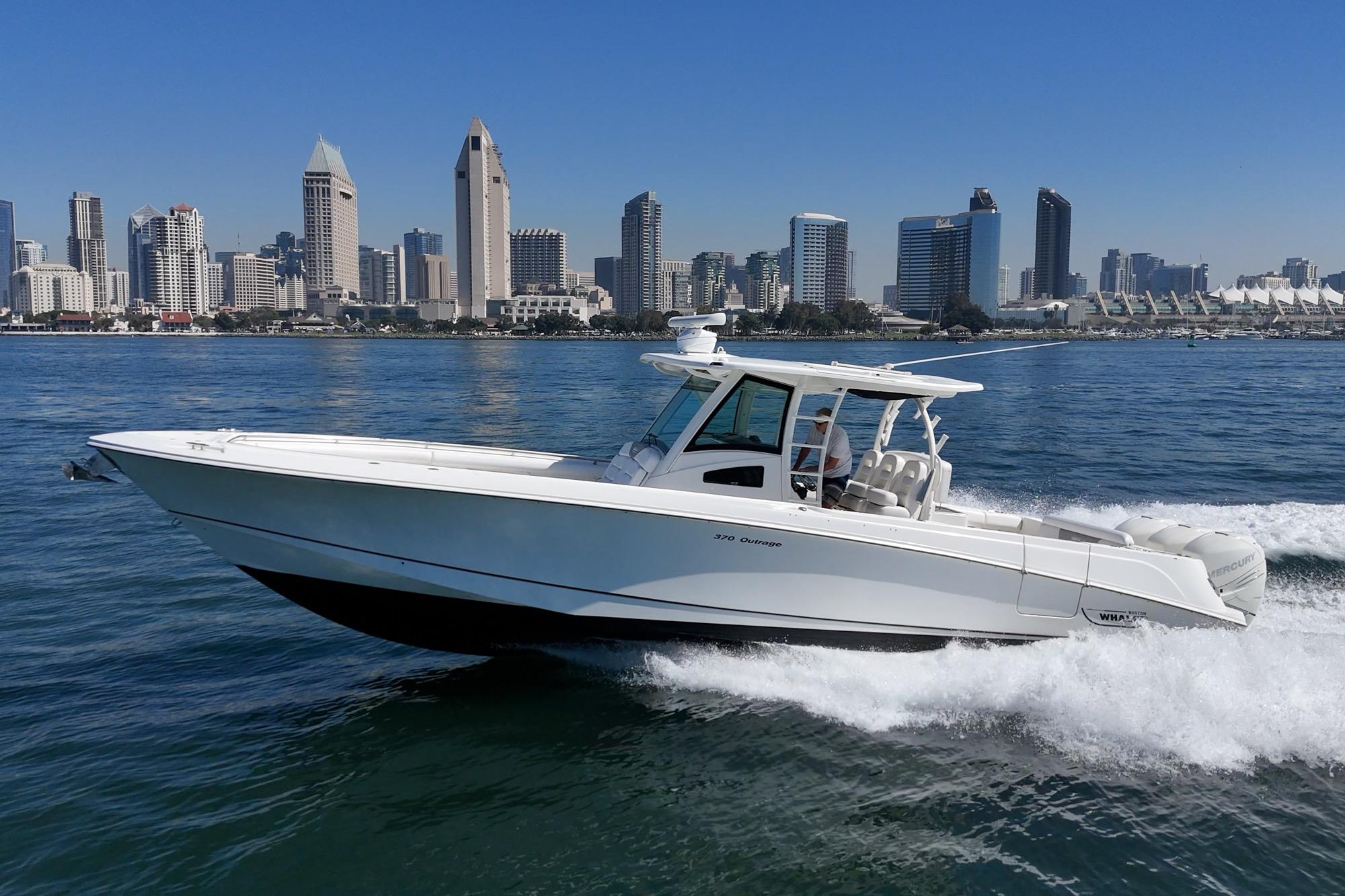 2015 Boston Whaler 370 Outrage cruising near city skyline on a sunny day.