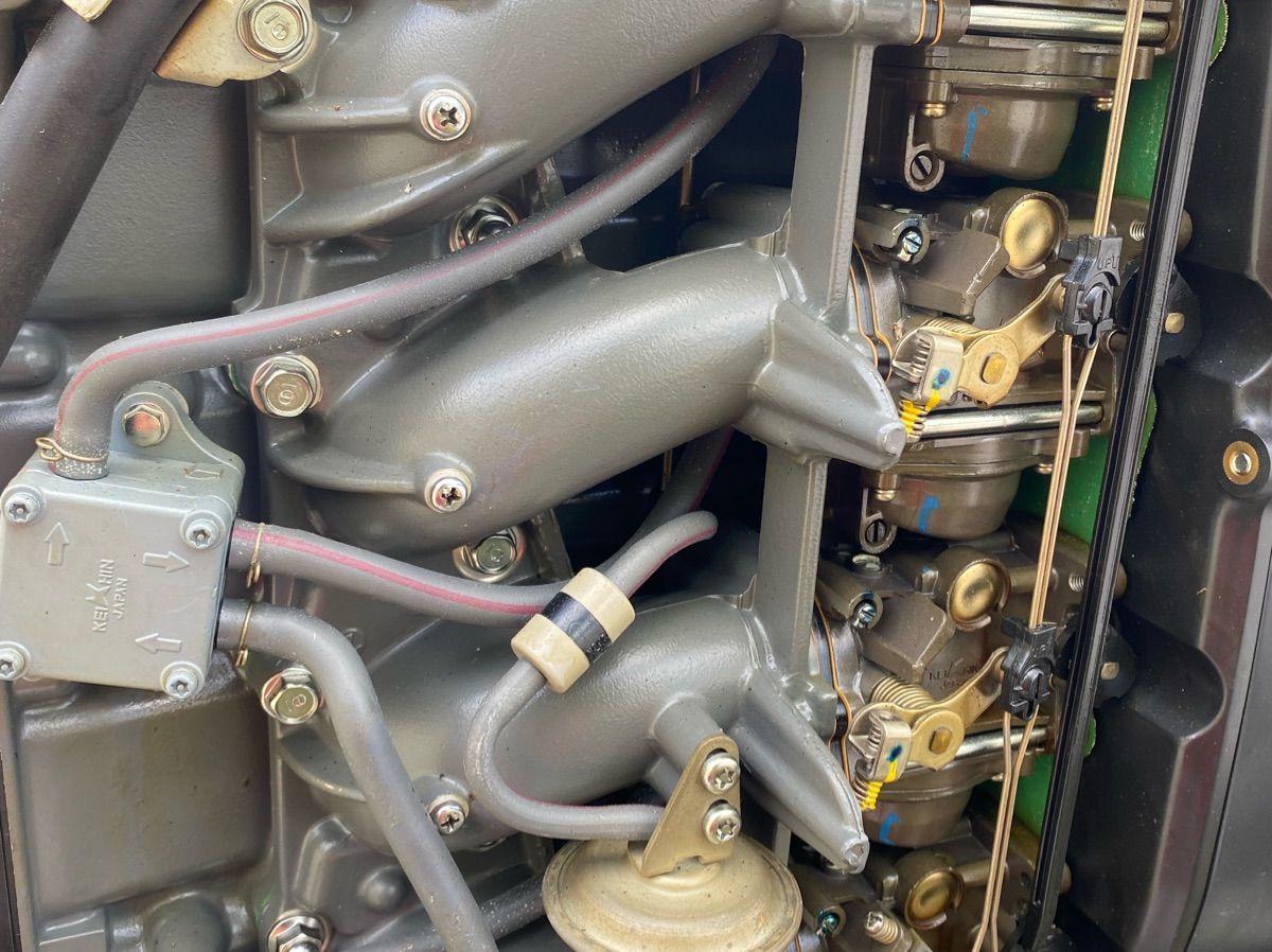 Close-up of a boat engine with visible hoses and metal components.