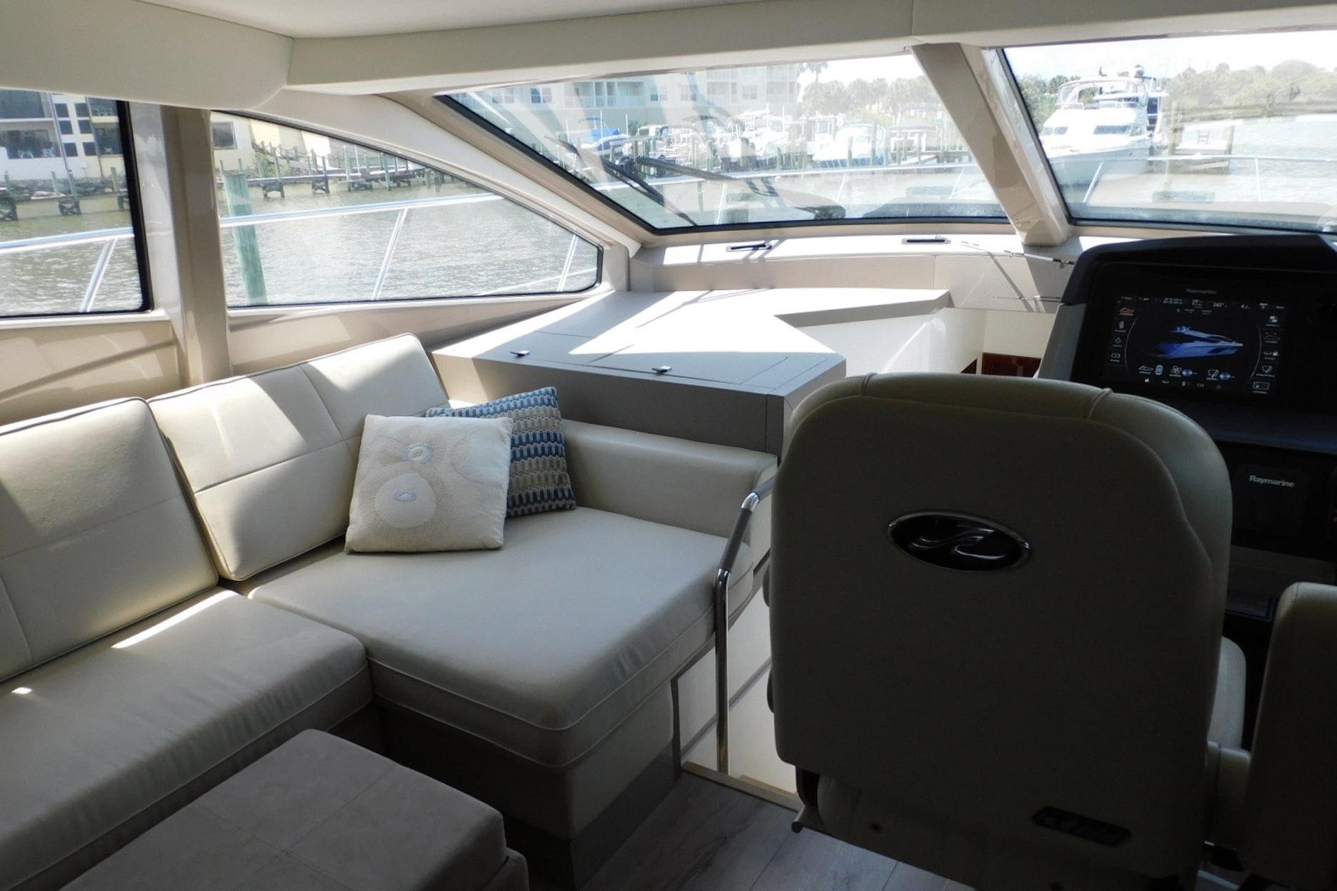 Luxurious interior of 2019 Sea Ray L550 yacht with plush seating and modern helm.