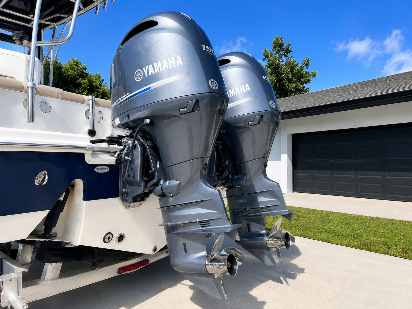 Two Yamaha outboard engines on a Sportsman Open 252 Center Console boat, parked on a driveway.