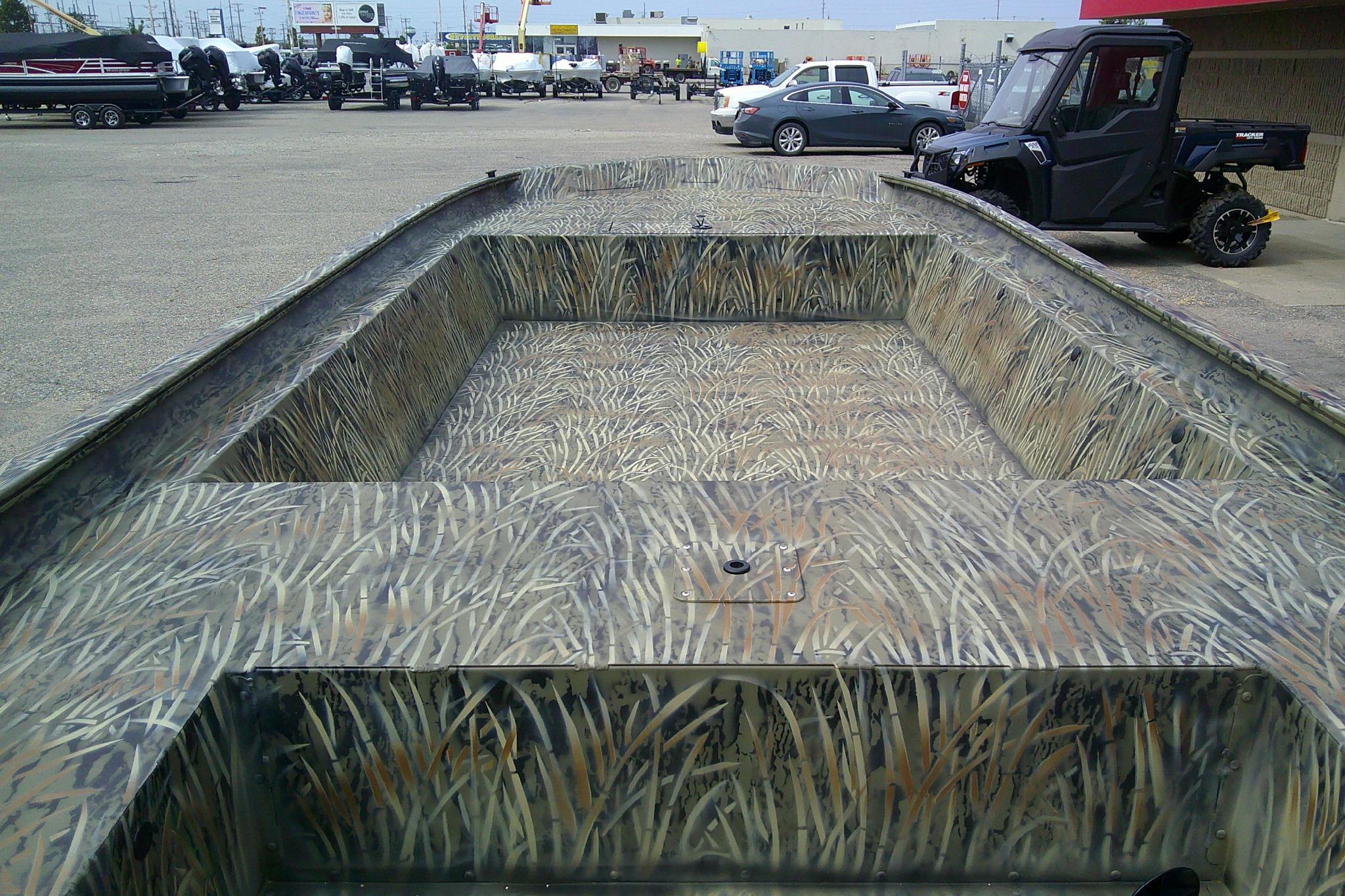2026 Tracker Grizzly 1860 Utility boat with camouflage design in a dealership lot.
