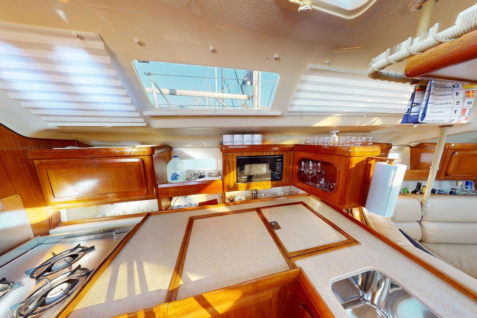 Interior of 1997 Hunter Legend 40.5 yacht kitchen with wooden cabinetry and modern amenities.