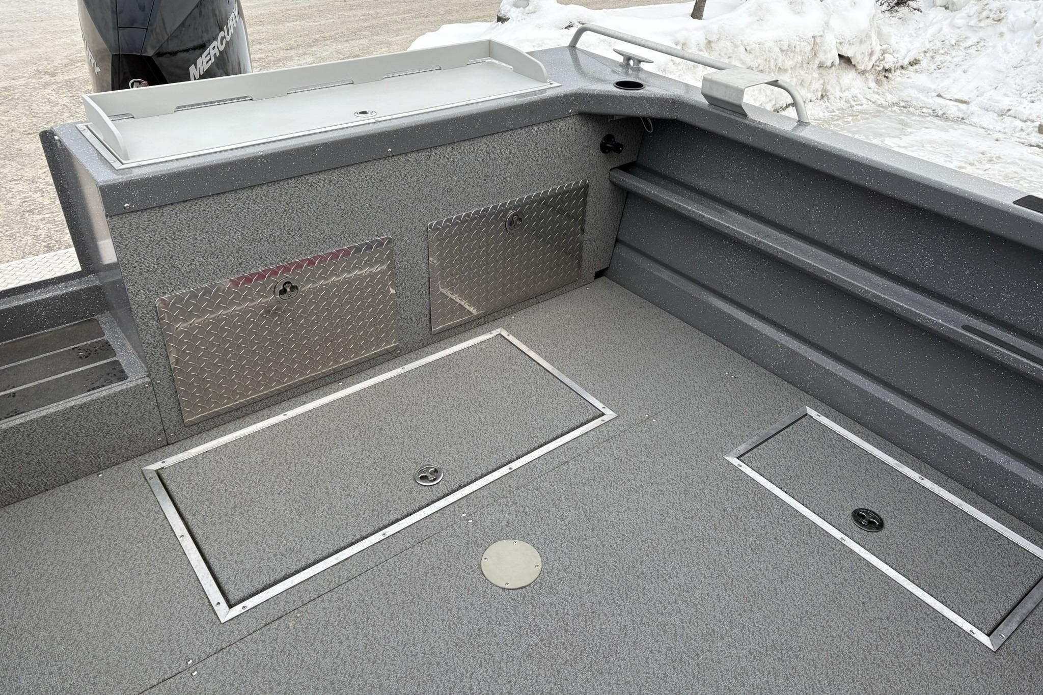 2024 Spartan 240 Maximus Pro boat interior with storage compartments and snow background.