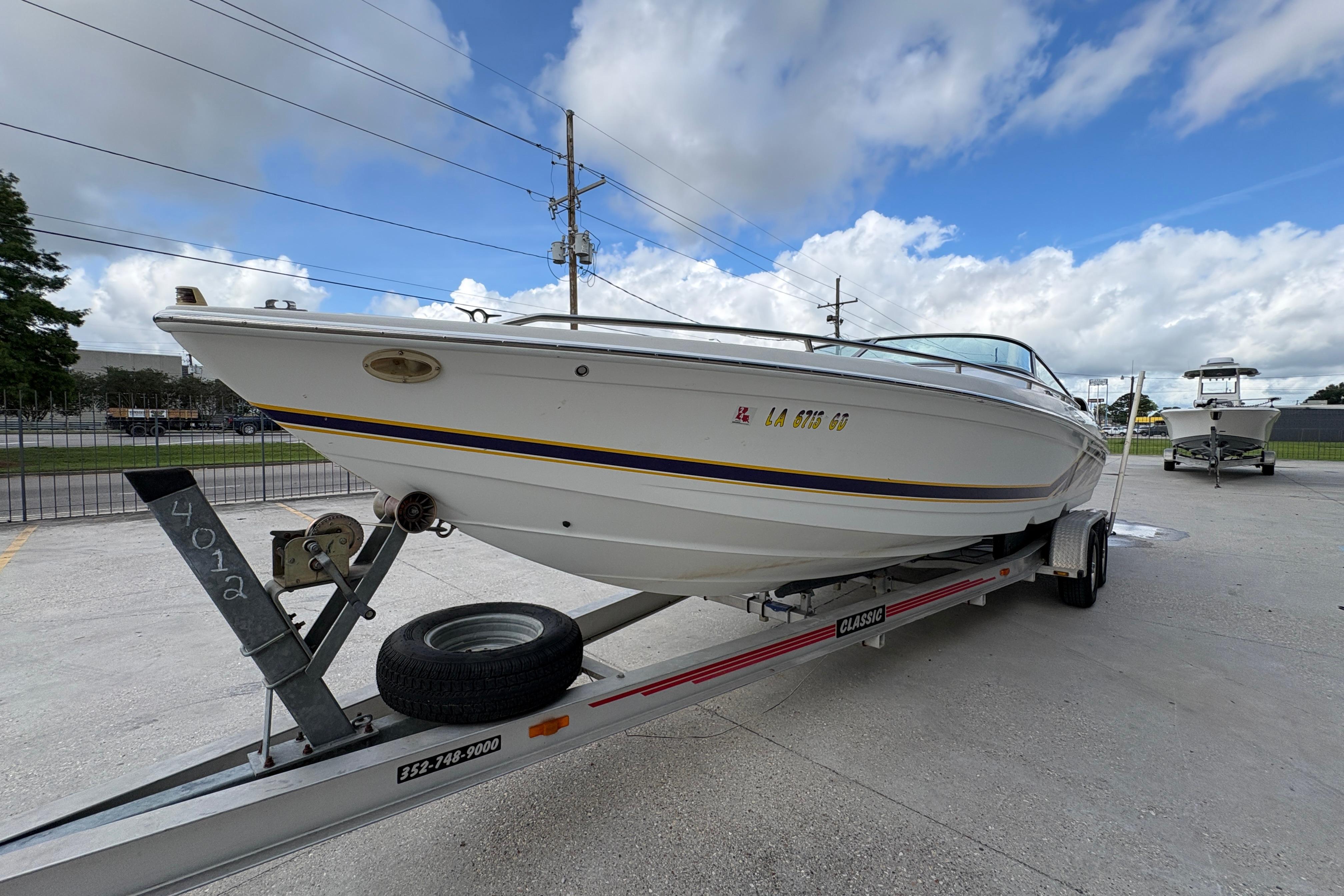 2002 Formula 292 FASTech boat on trailer under cloudy sky.