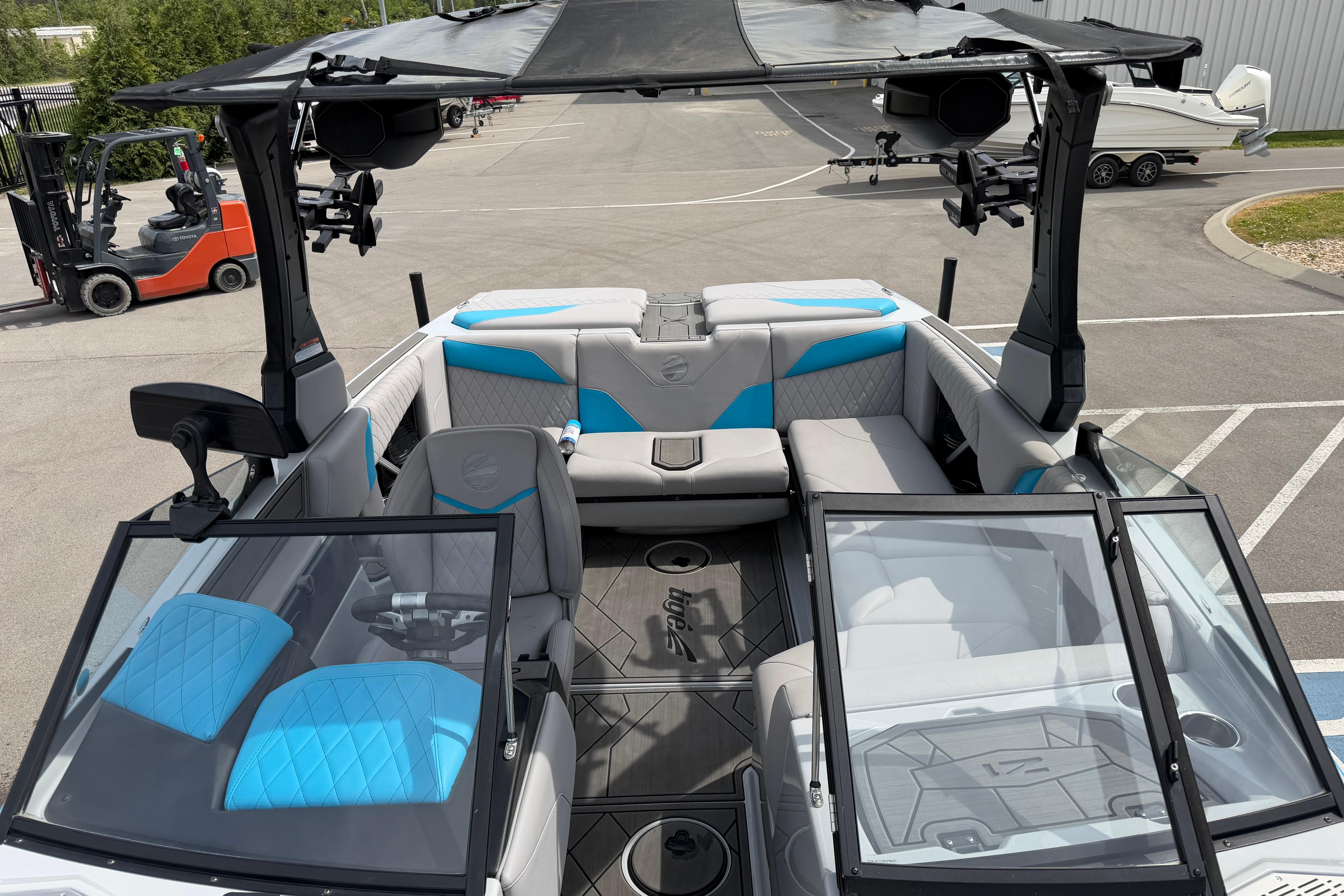 2024 Tigé Z1 boat interior with blue and gray seating, open windshield, and modern design.