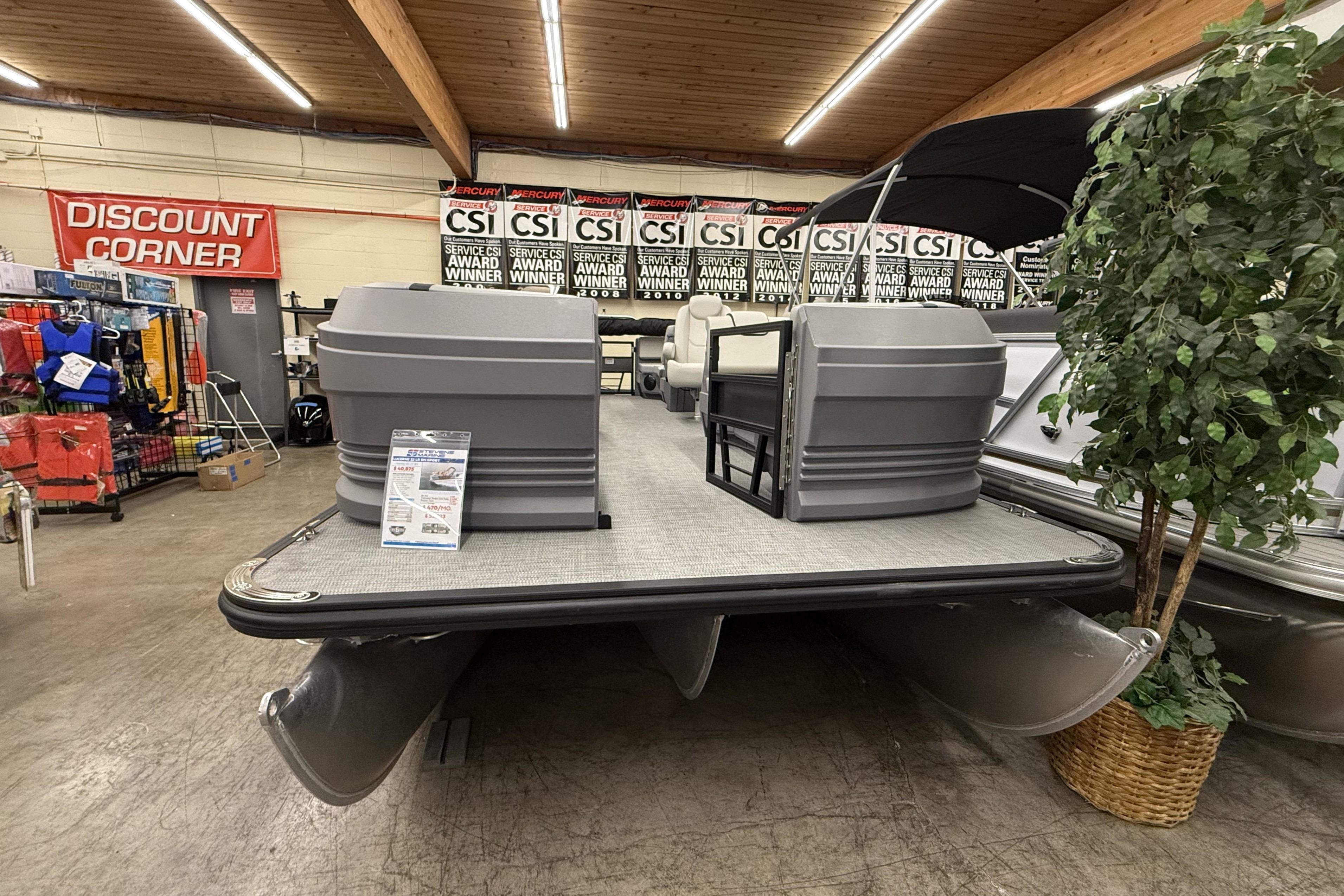 2025 SunChaser Lucerne 22 LR DH pontoon boat displayed indoors with award banners.