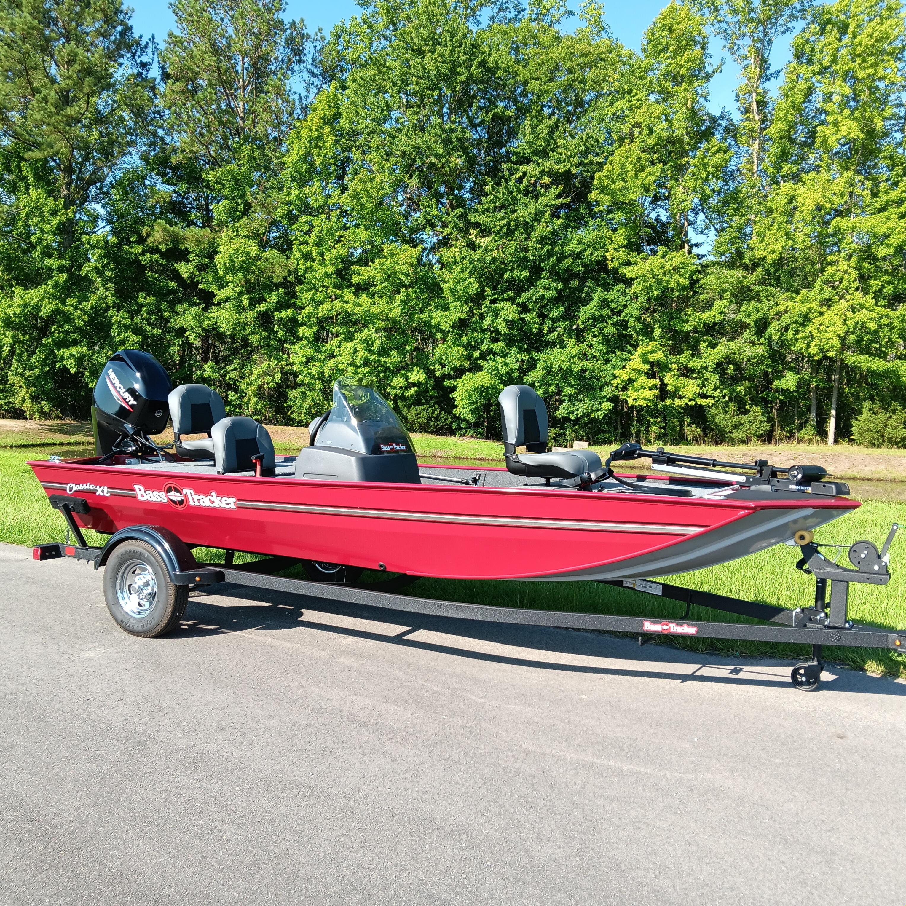 2026 Tracker Bass Tracker Classic XL boat on trailer, parked on road with lush green trees.