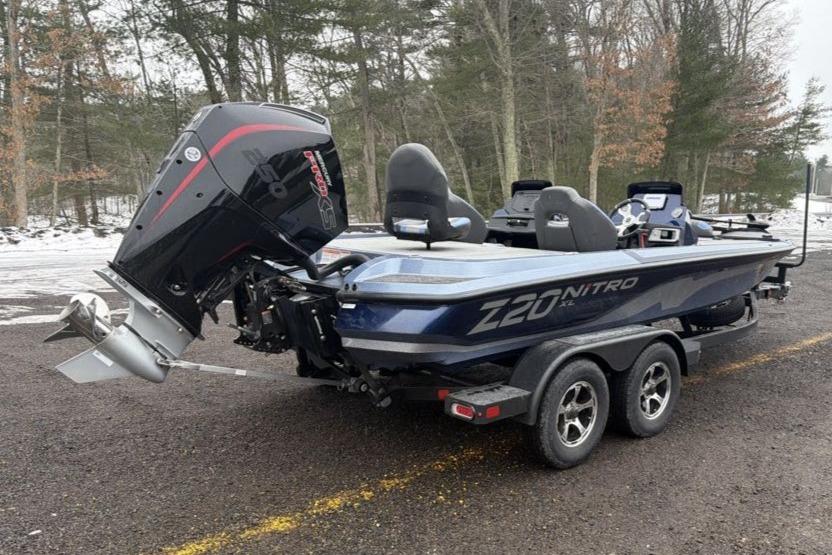 2026 Nitro Z20 XL boat with powerful outboard motor, parked on a snowy forest road.
