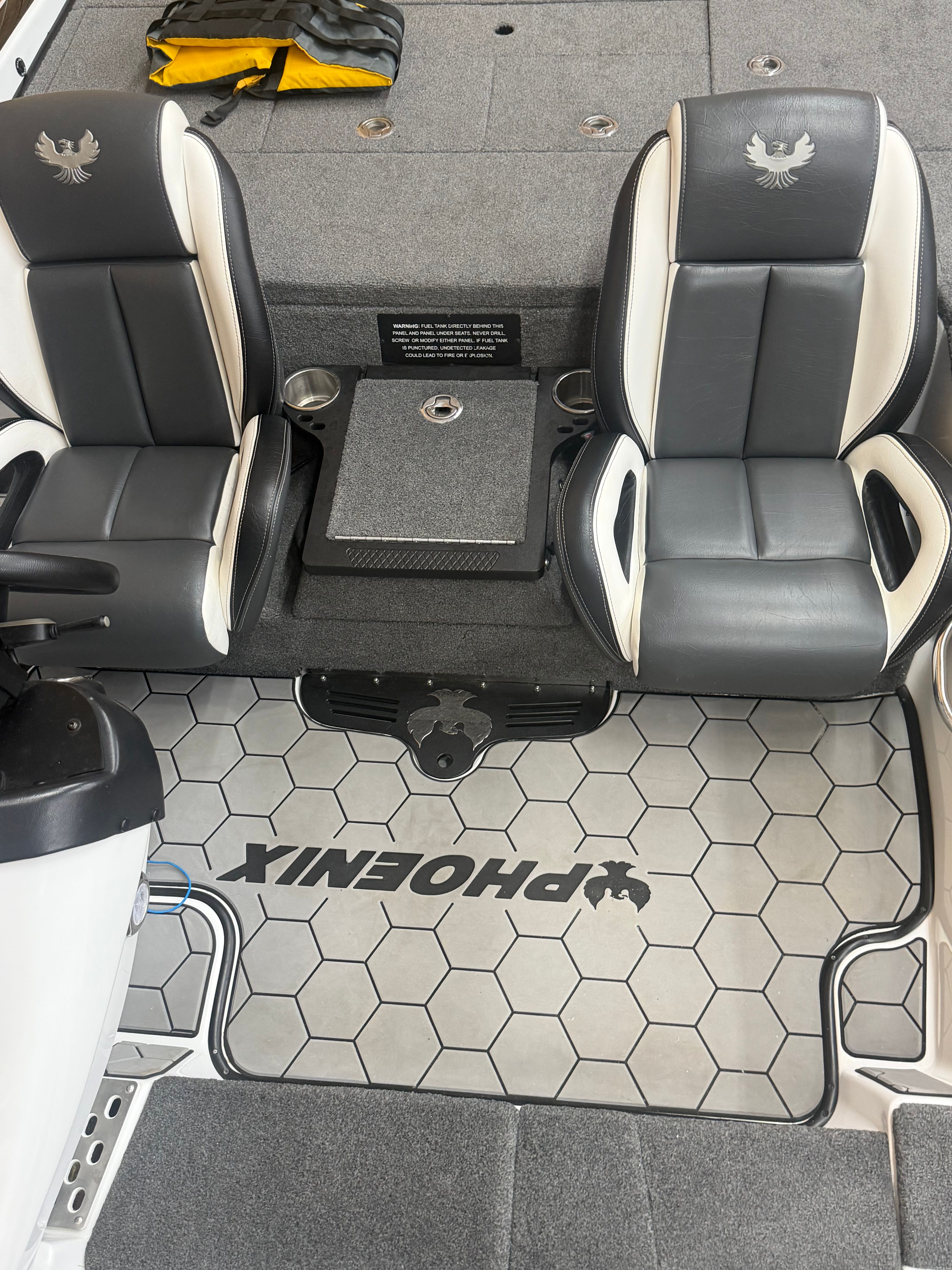 Interior view of a Phoenix 920 Elite boat with two black seats and gray flooring.